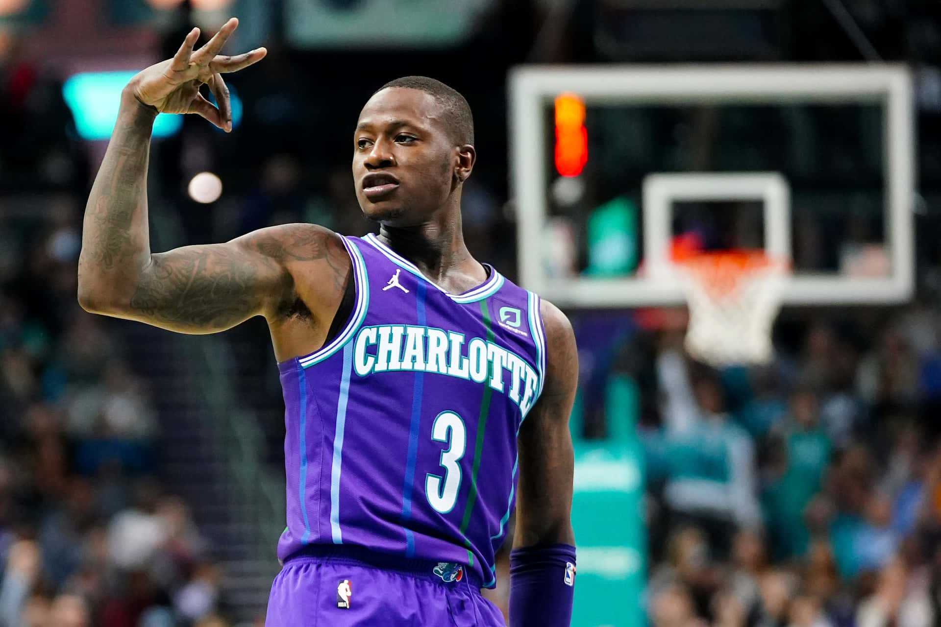身穿紫色夏洛特球衣的籃球運動員在比賽中做手勢。 — NBA 壁紙