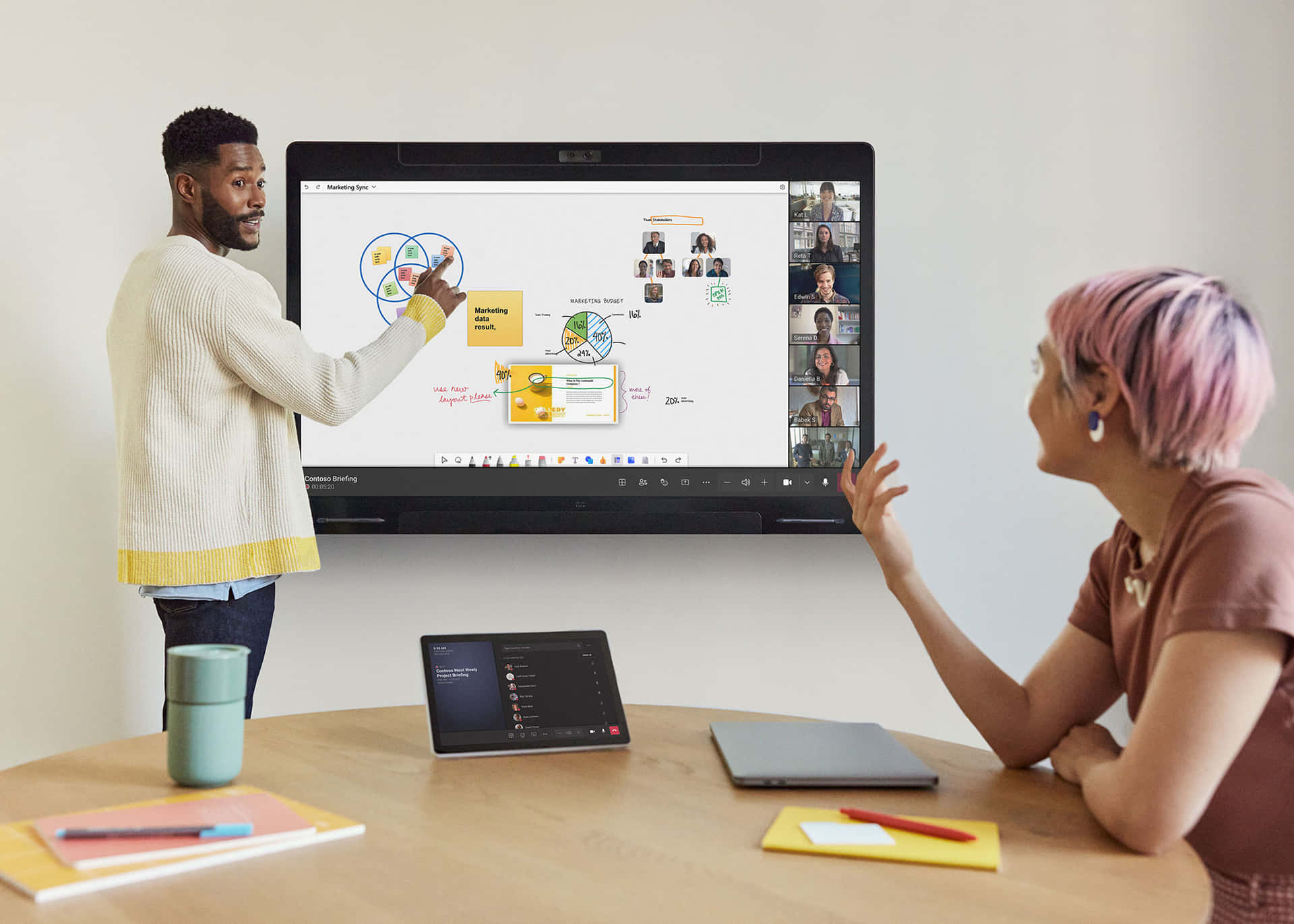 會議室中兩人使用大型螢幕與遠端參與者進行協作工作。 — Microsoft Teams 壁紙