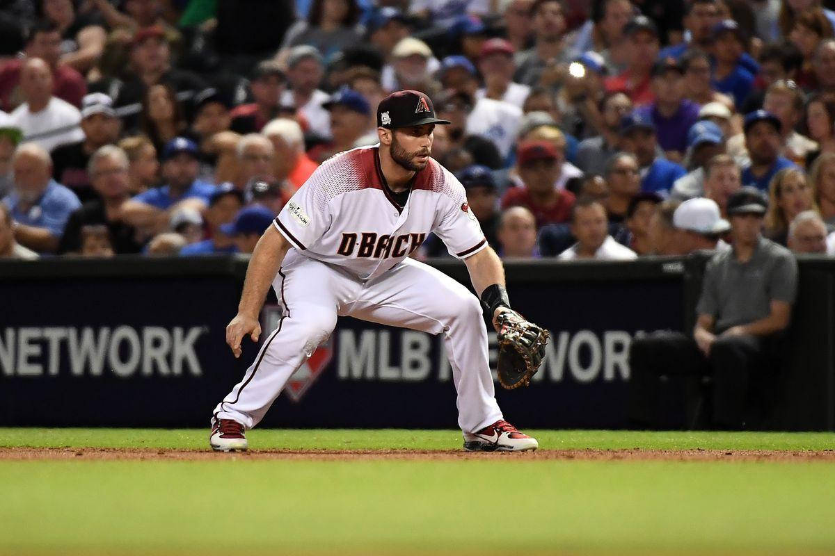 身穿白色和紅色球衣的棒球手在比賽中蹲伏在球場上。 — MLB 壁紙