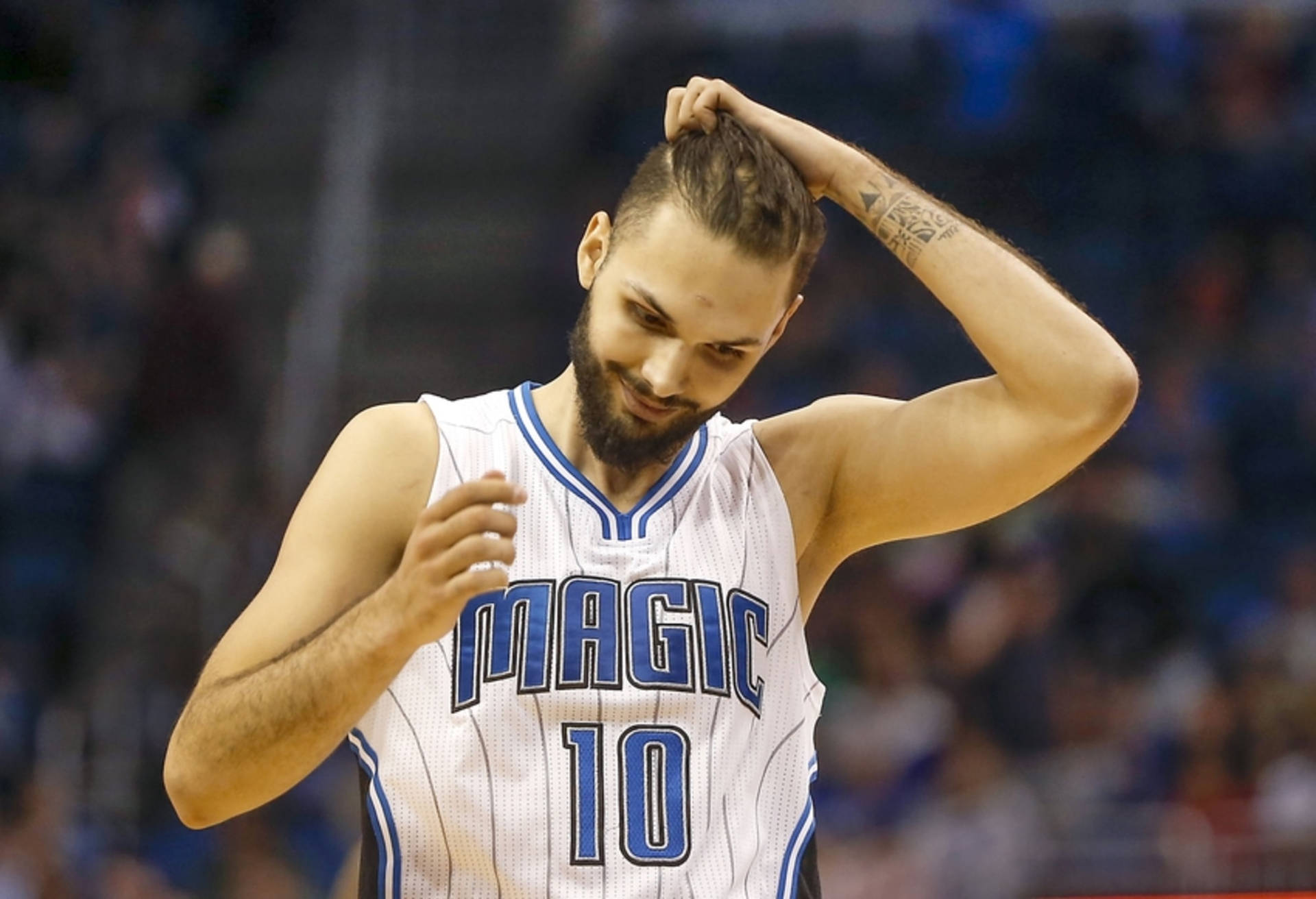 身穿奧蘭多魔術隊球衣的籃球運動員微笑著用手梳理頭髮。 — NBA 壁紙