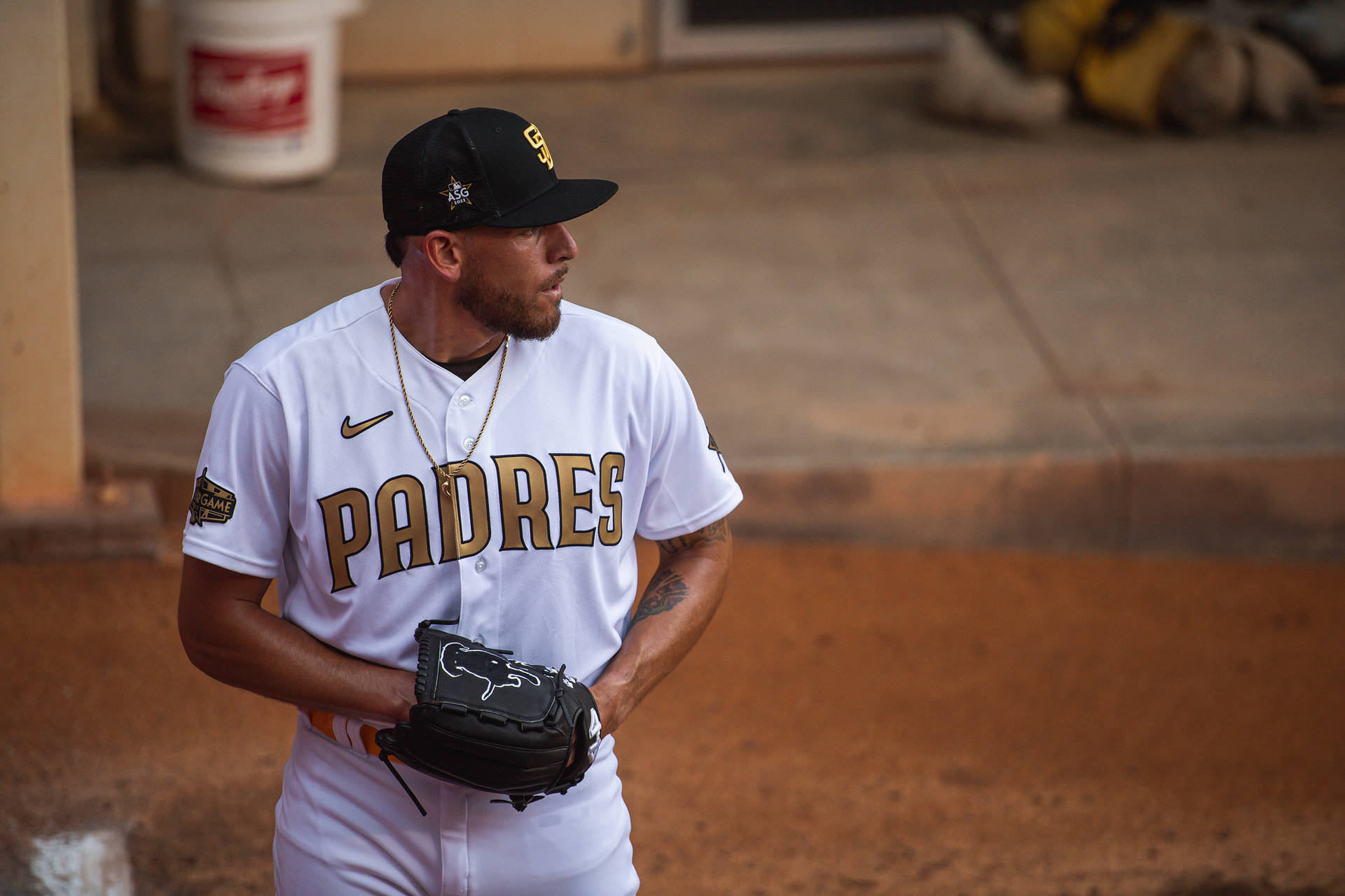 身穿教士隊球衣的棒球選手在球員休息區手持手套。 — MLB 壁紙