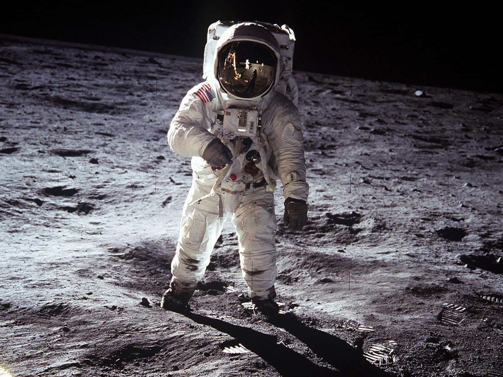 Neil Armstrong 桌布 壁紙 — 一名身穿白色太空衣的太空人站在月球灰色的表面上，背後是黑色的天空。