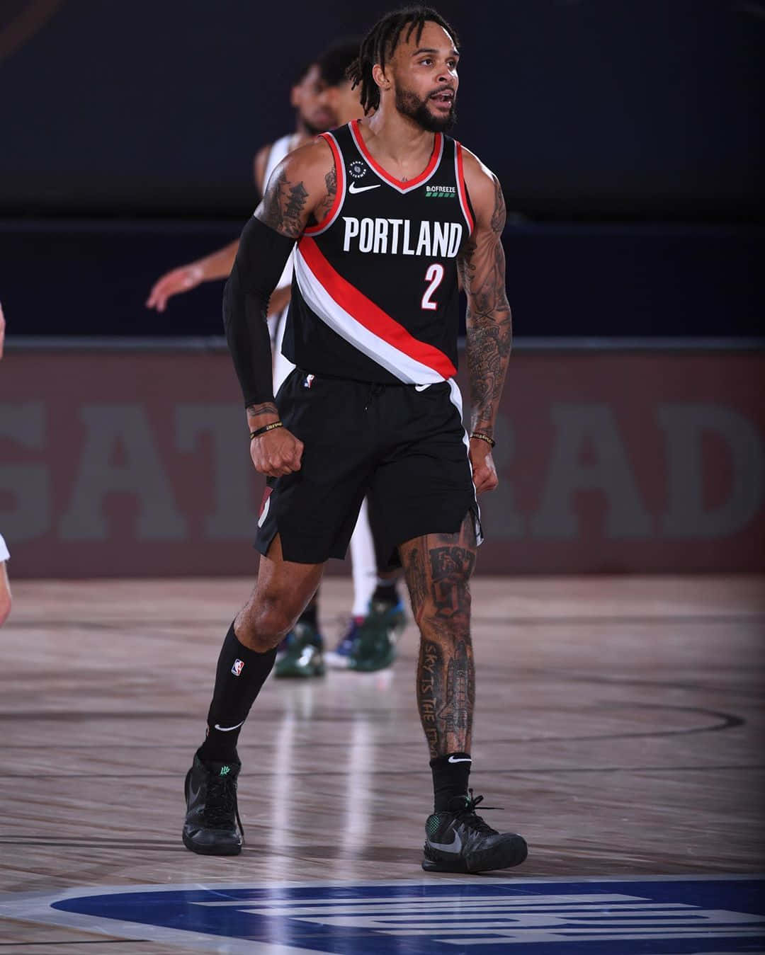 身穿波特蘭拓荒者球衣的籃球運動員在球場上展示刺青。 — NBA 壁紙