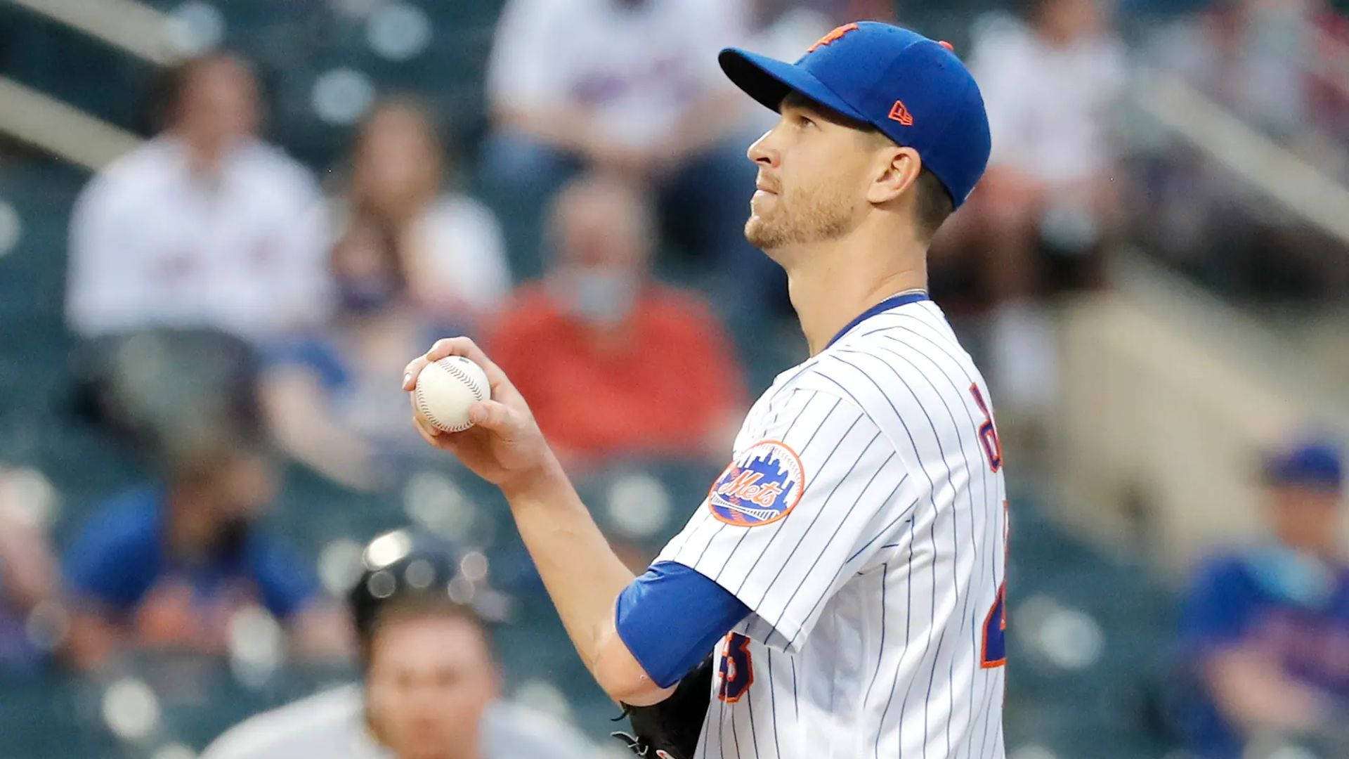 身穿大都會隊球衣的棒球投手在日間比賽中準備投球。 — MLB 壁紙