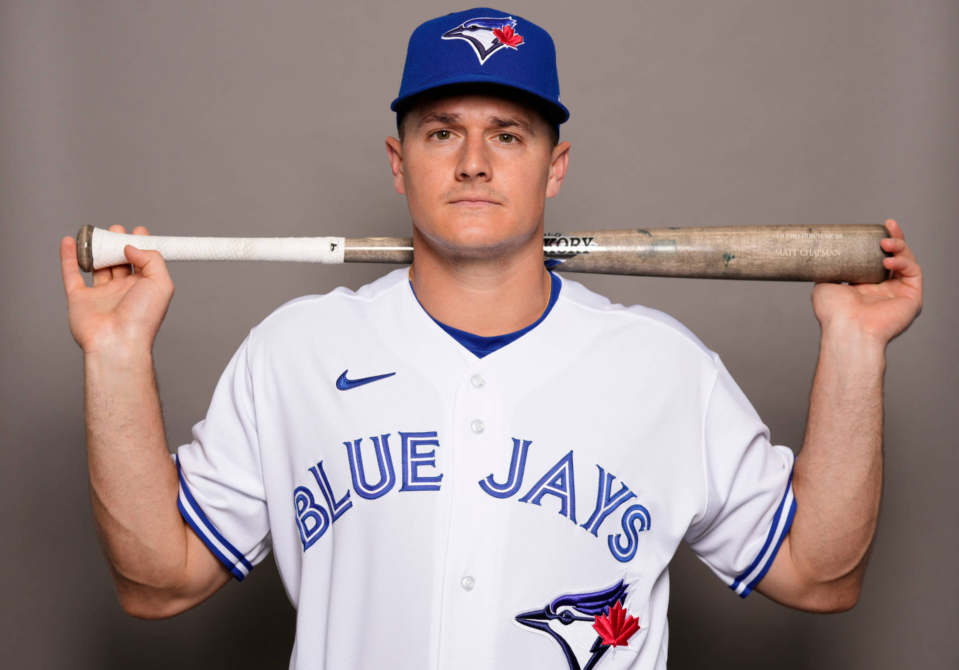 身穿藍鳥隊球衣的棒球運動員將球棒扛在肩上。 — MLB 壁紙