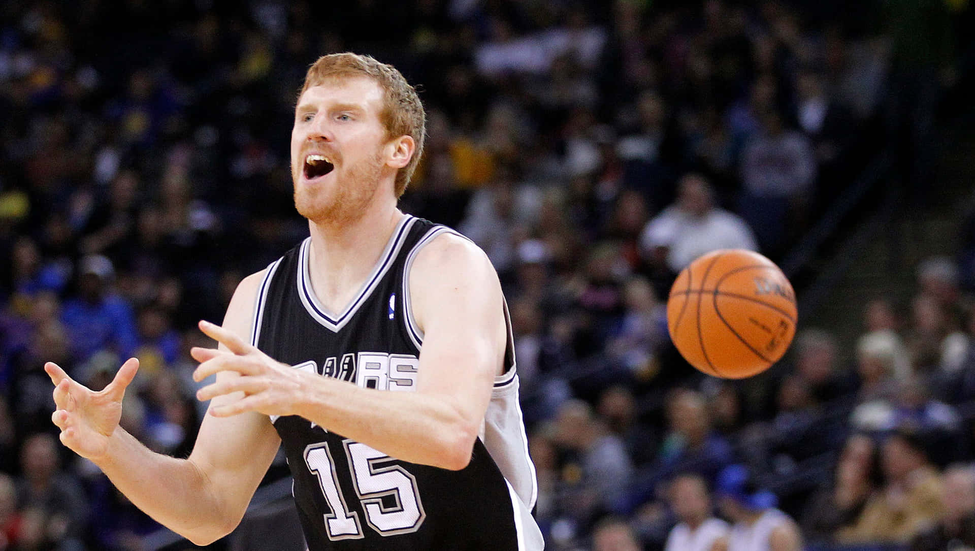 身穿黑白球衣背號15的籃球運動員與橙色球一起動作。 — NBA 壁紙