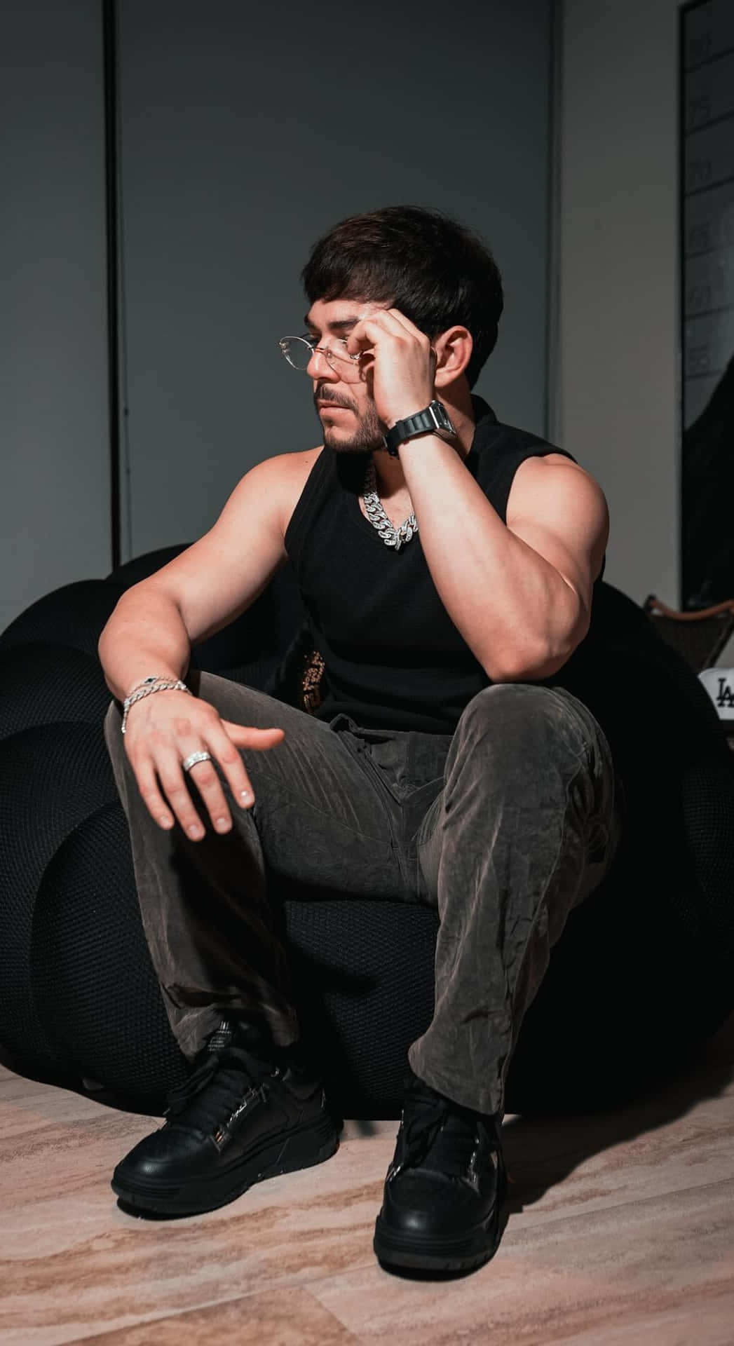  壁紙 — 一名身穿黑色背心及戴眼鏡的男子，在昏暗的房間裡若有所思地坐在豆袋椅上。