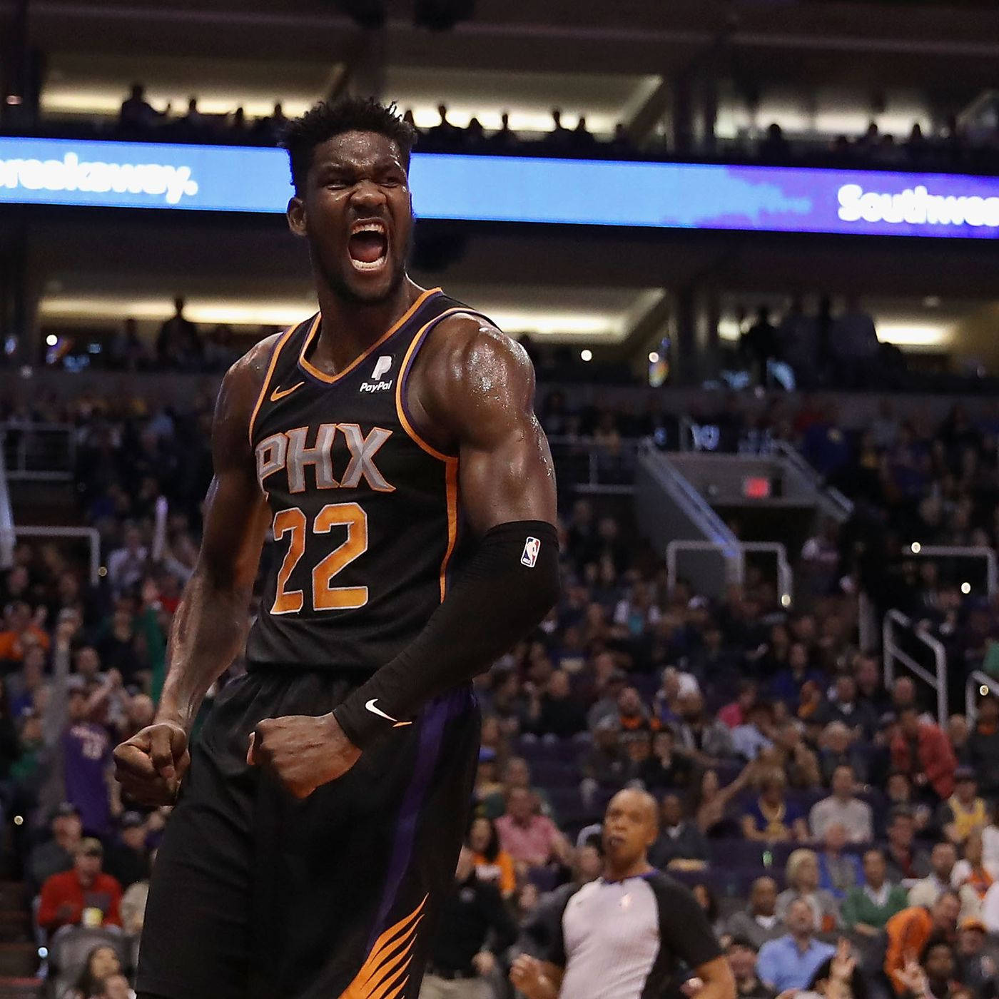 身穿鳳凰城太陽隊球衣的籃球運動員握緊拳頭咆哮。 — NBA 壁紙