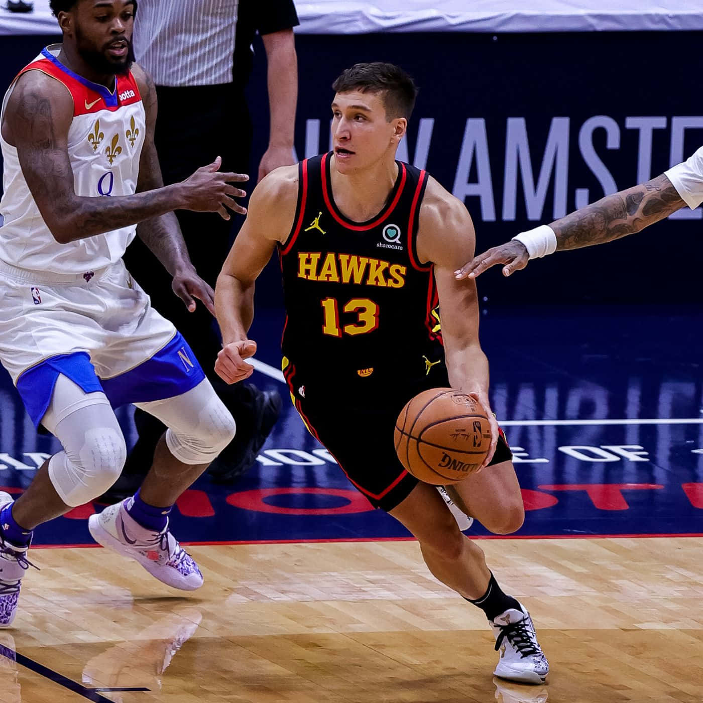 身穿老鷹隊球衣的籃球運動員在比賽中運球，附近有防守球員。 — NBA 壁紙