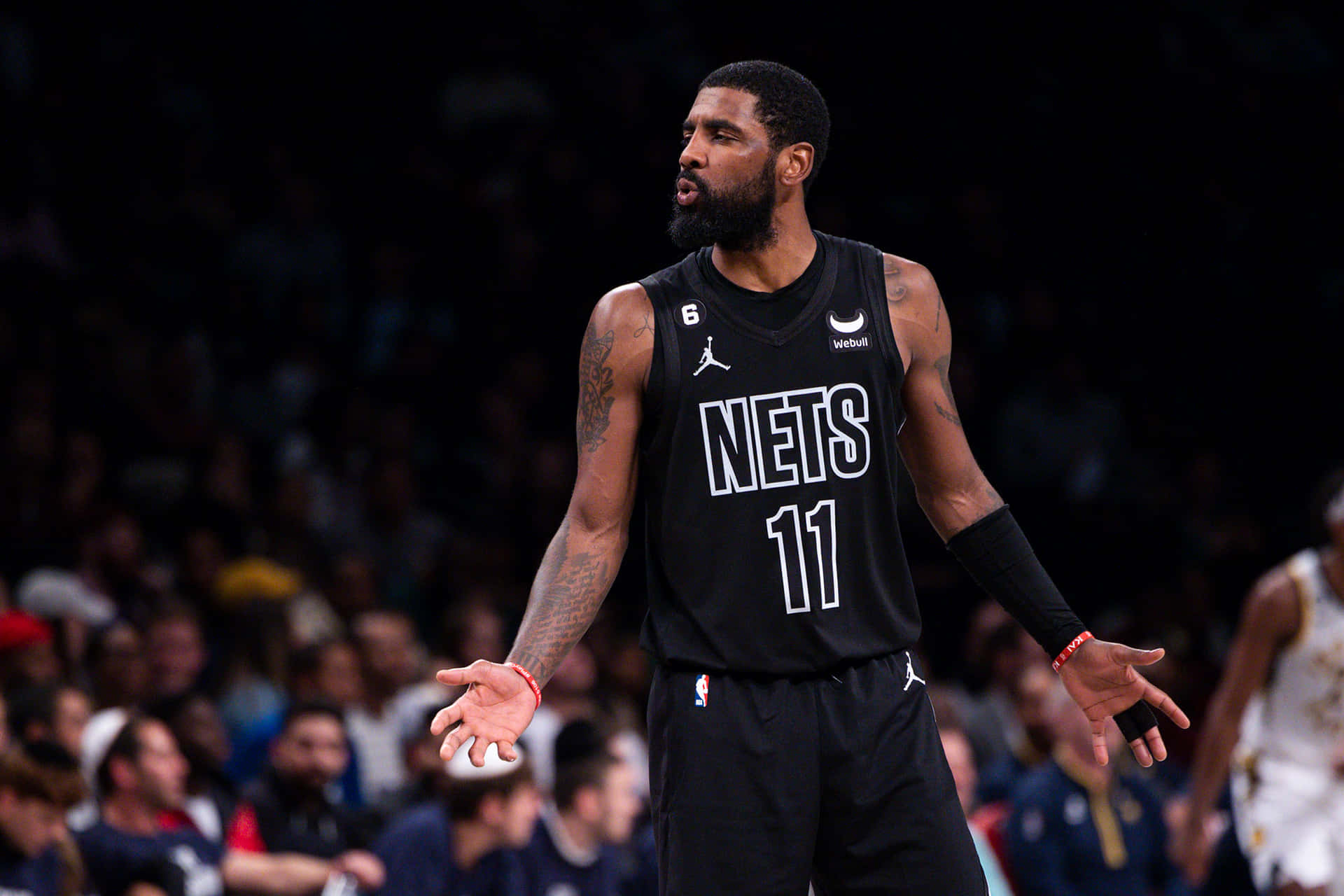 身穿黑色Nets球衣背號11的籃球運動員比賽時做手勢。 — NBA 壁紙