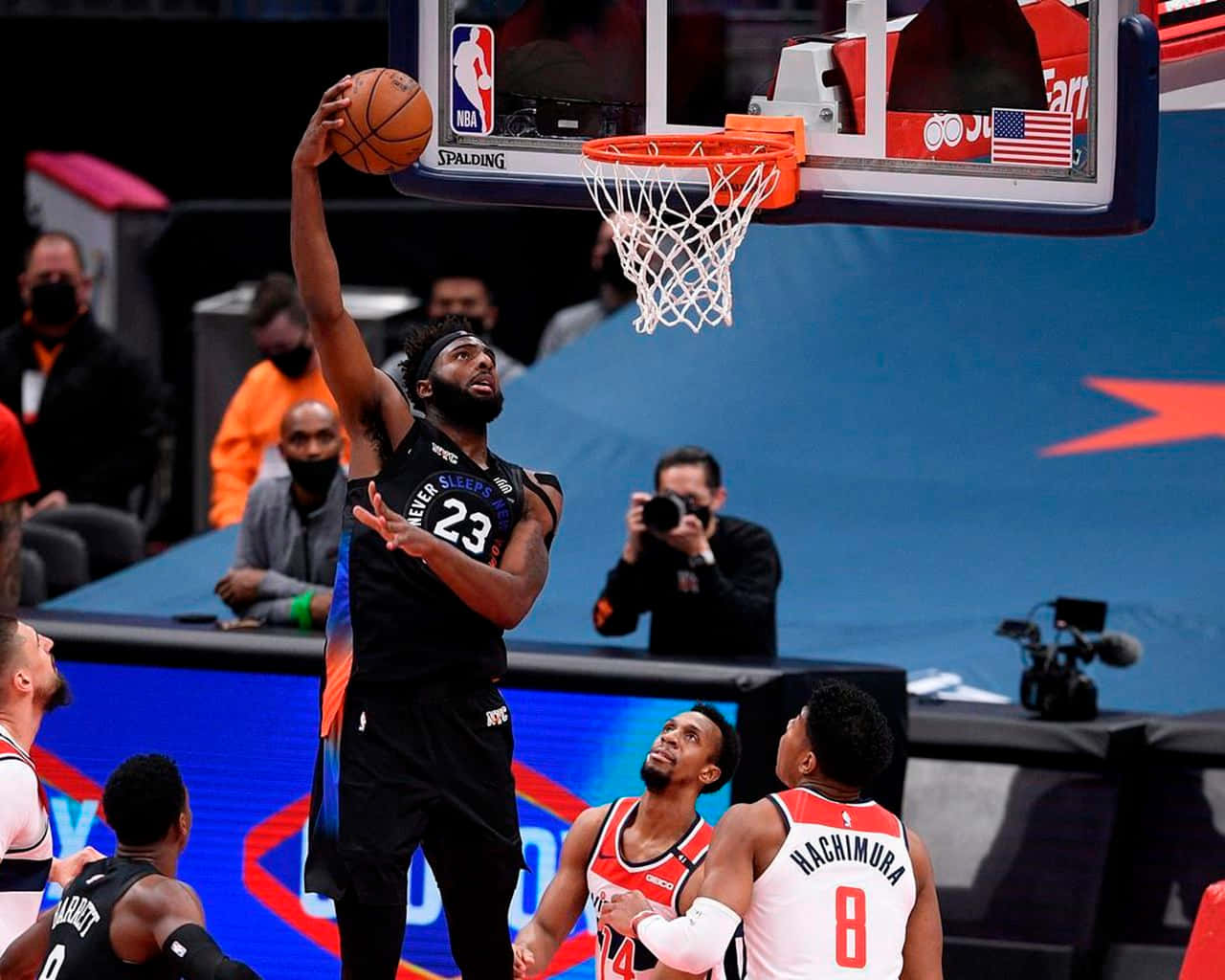 籃球運動員在比賽中越過防守球員灌籃。 — NBA 壁紙