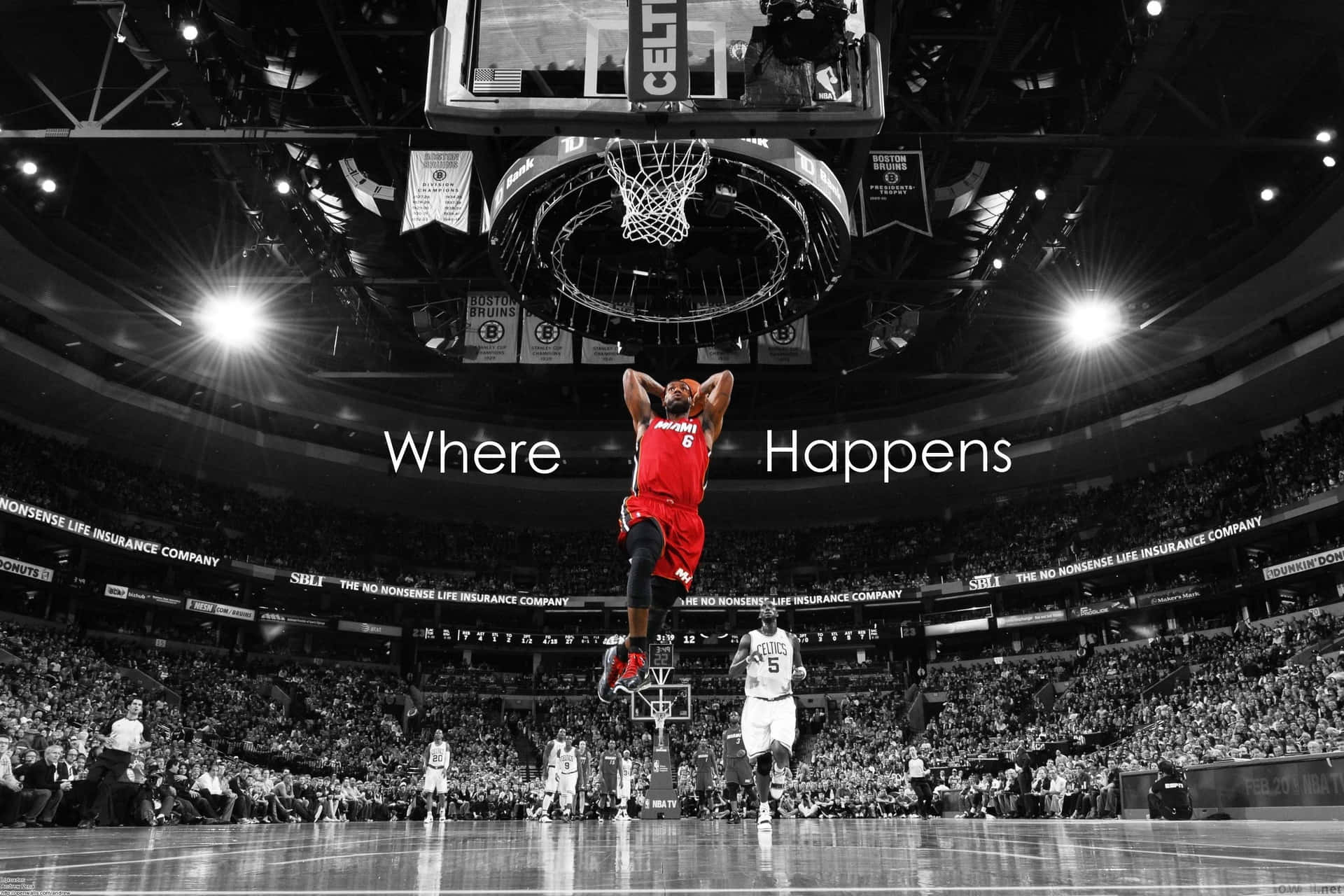 身穿紅色球衣的籃球運動員在黑白競技場中當著觀眾灌籃。 — NBA 壁紙