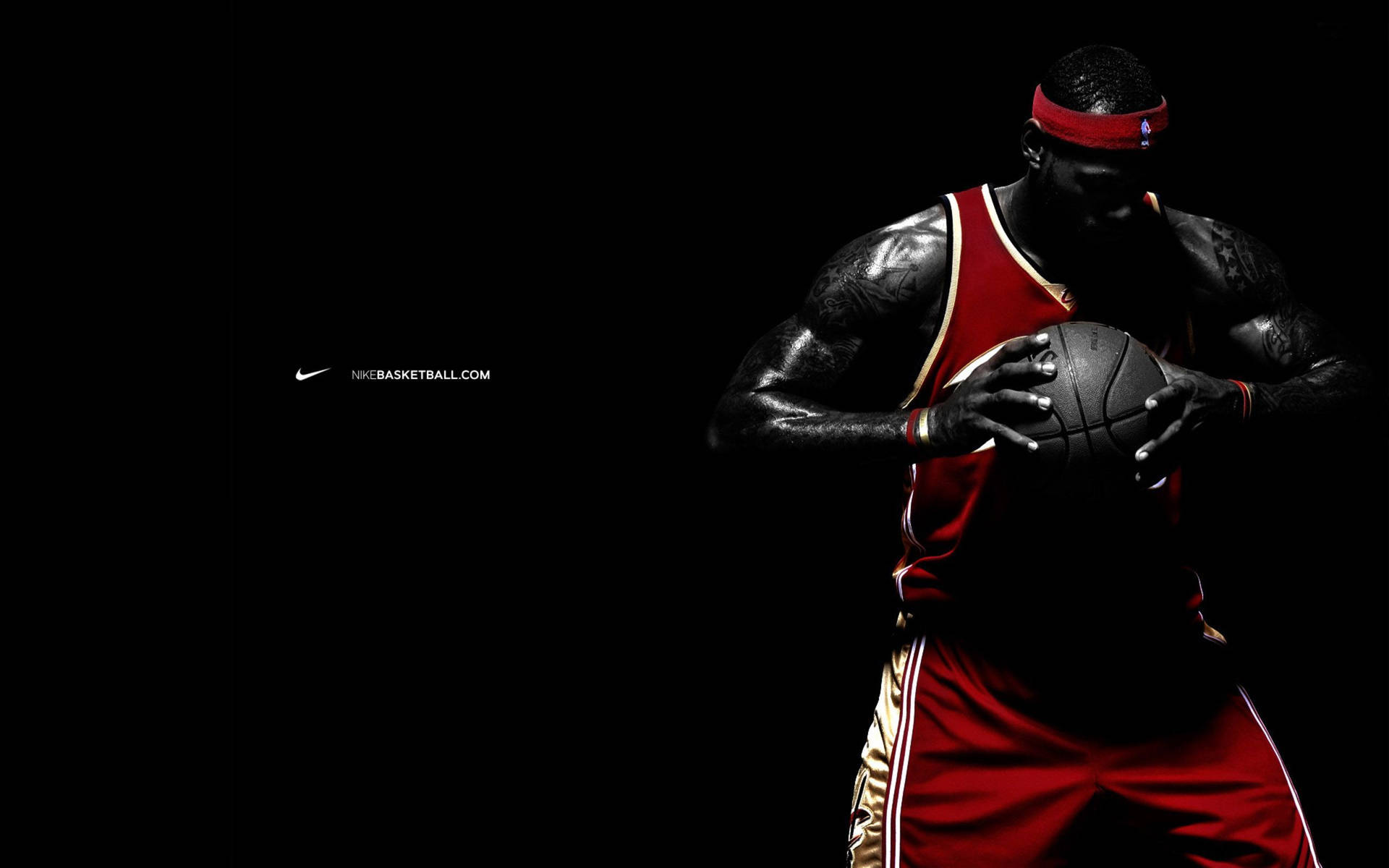 運動型籃球運動員穿著紅色制服在黑色背景下拿著一個球。 — NBA 壁紙