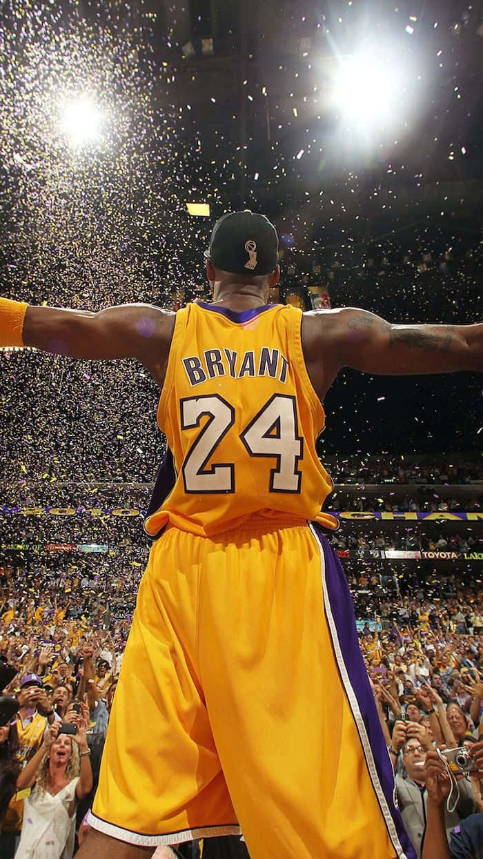 身穿黃色球衣的籃球運動員在彩紙飄落中張開雙臂慶祝勝利。 — 美學科比 壁紙