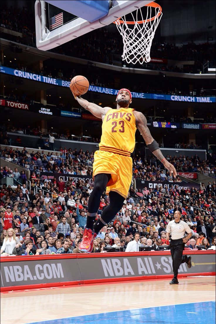  壁紙 — 一名身穿黃色騎士隊球衣的籃球運動員在NBA比賽中於半空中灌籃，下方擠滿了歡呼的觀眾。