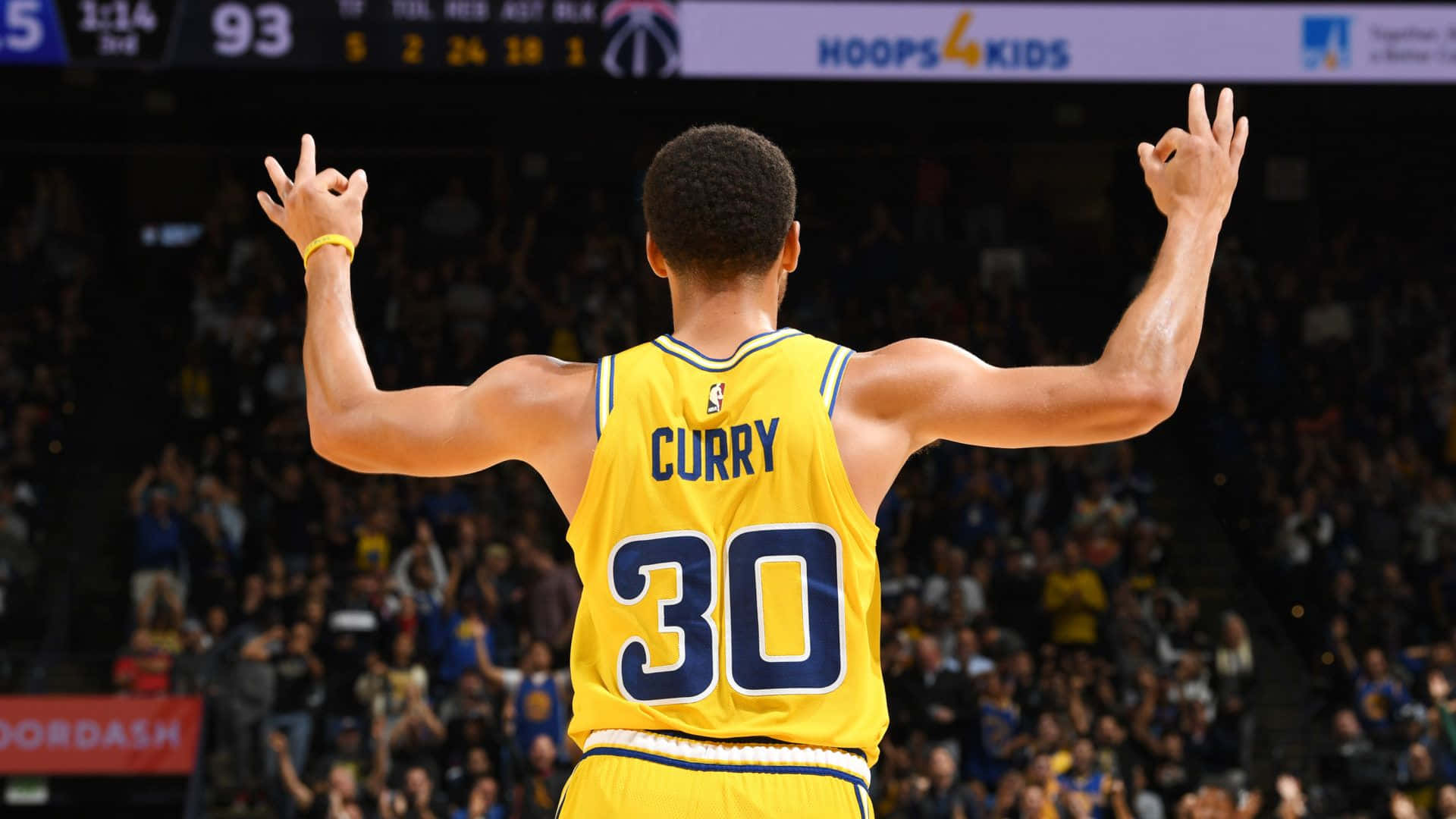 籃球運動員史蒂芬柯瑞在座無虛席的球館高舉雙臂慶祝。 — NBA 壁紙