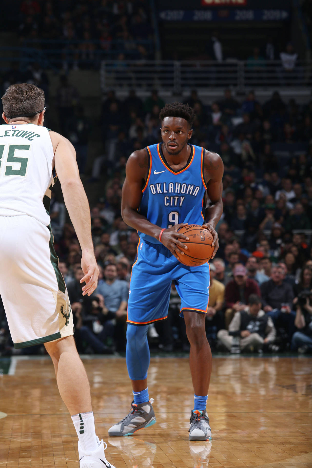 身穿藍色球衣的籃球運動員運球時被對手防守。 — NBA 壁紙