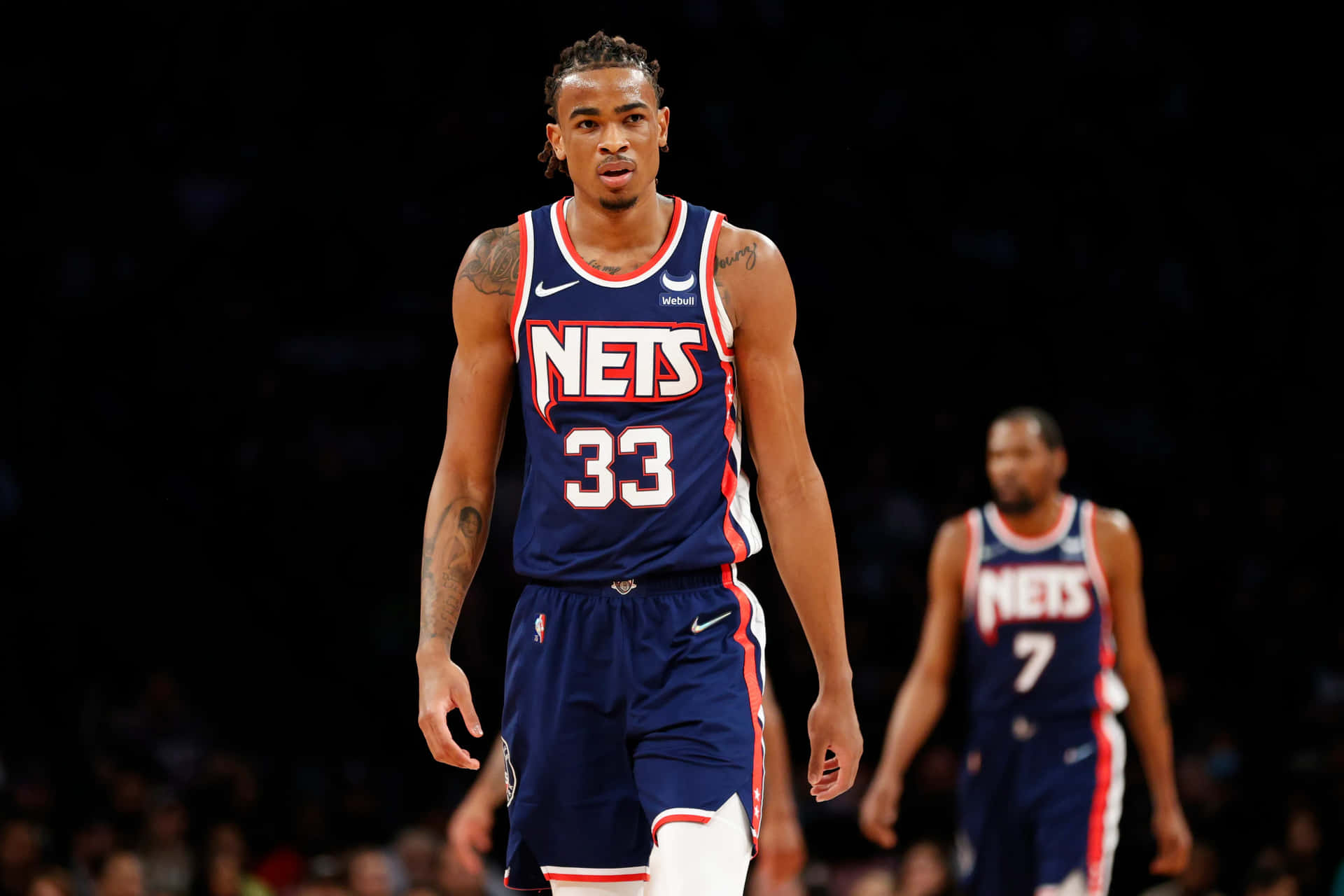 身穿籃網隊球衣的籃球運動員在比賽中走在球場上。 — NBA 壁紙