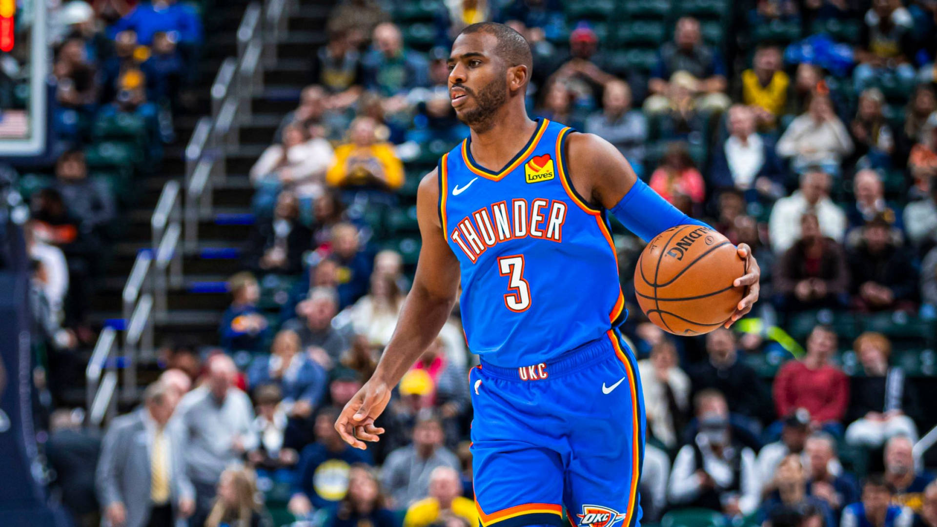 身穿藍色雷霆球衣的籃球運動員在比賽中運球。 — NBA 壁紙