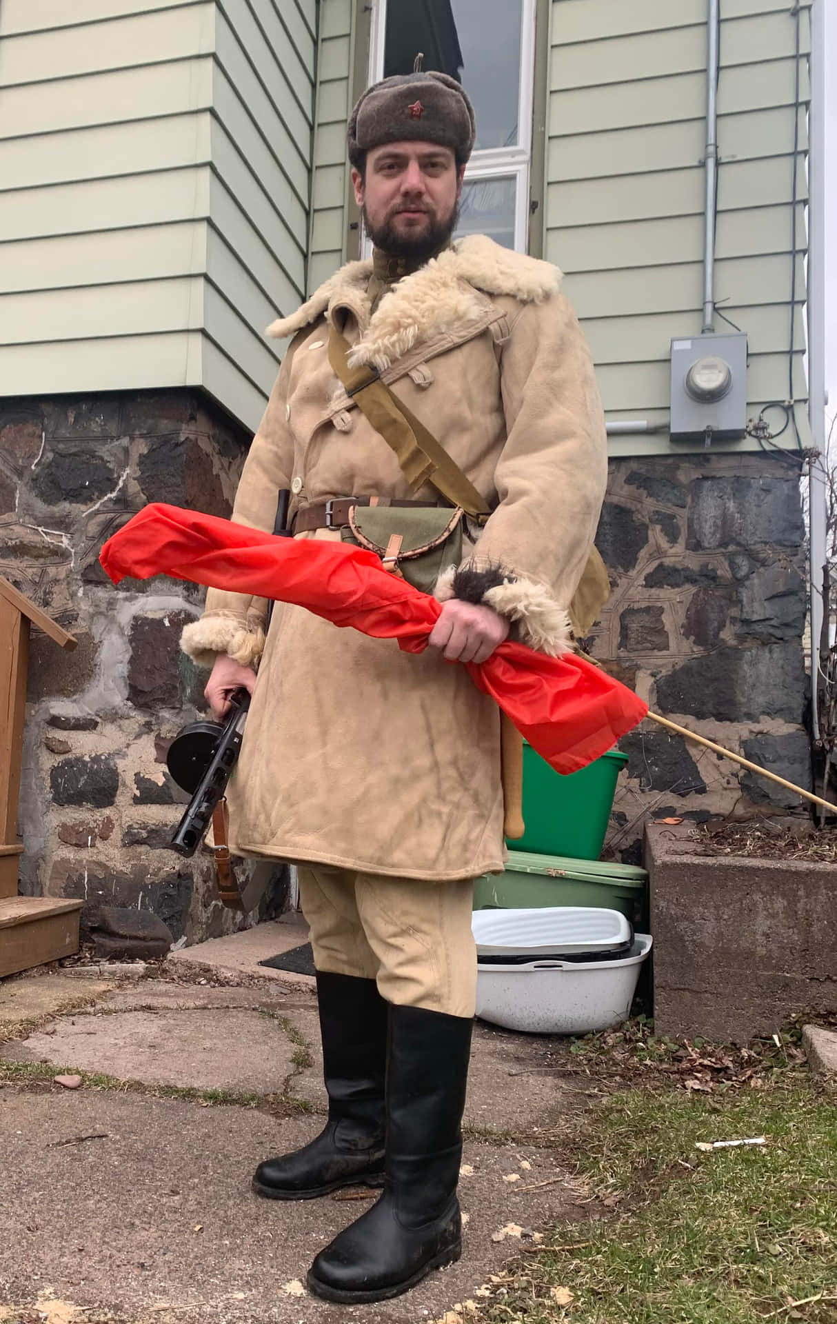  壁紙 — 一名身穿詳細蘇聯軍服的男子站在戶外，手持紅旗和步槍。