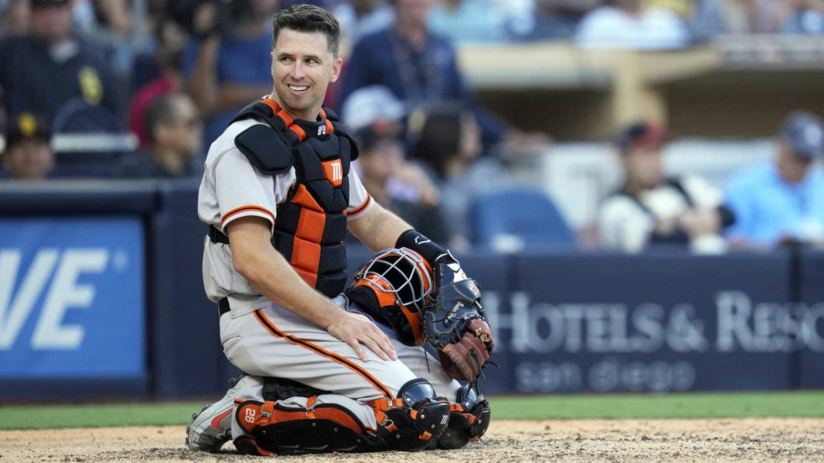 棒球捕手在比賽中穿著全套裝備微笑站在球場上。 — MLB 壁紙