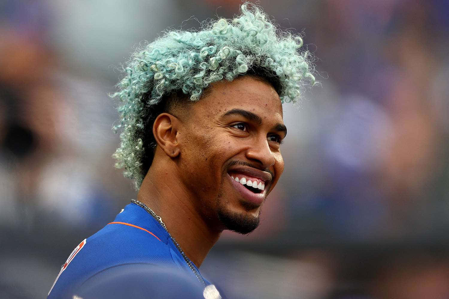 藍綠色捲髮的棒球運動員穿著藍色制服微笑。 — MLB 壁紙