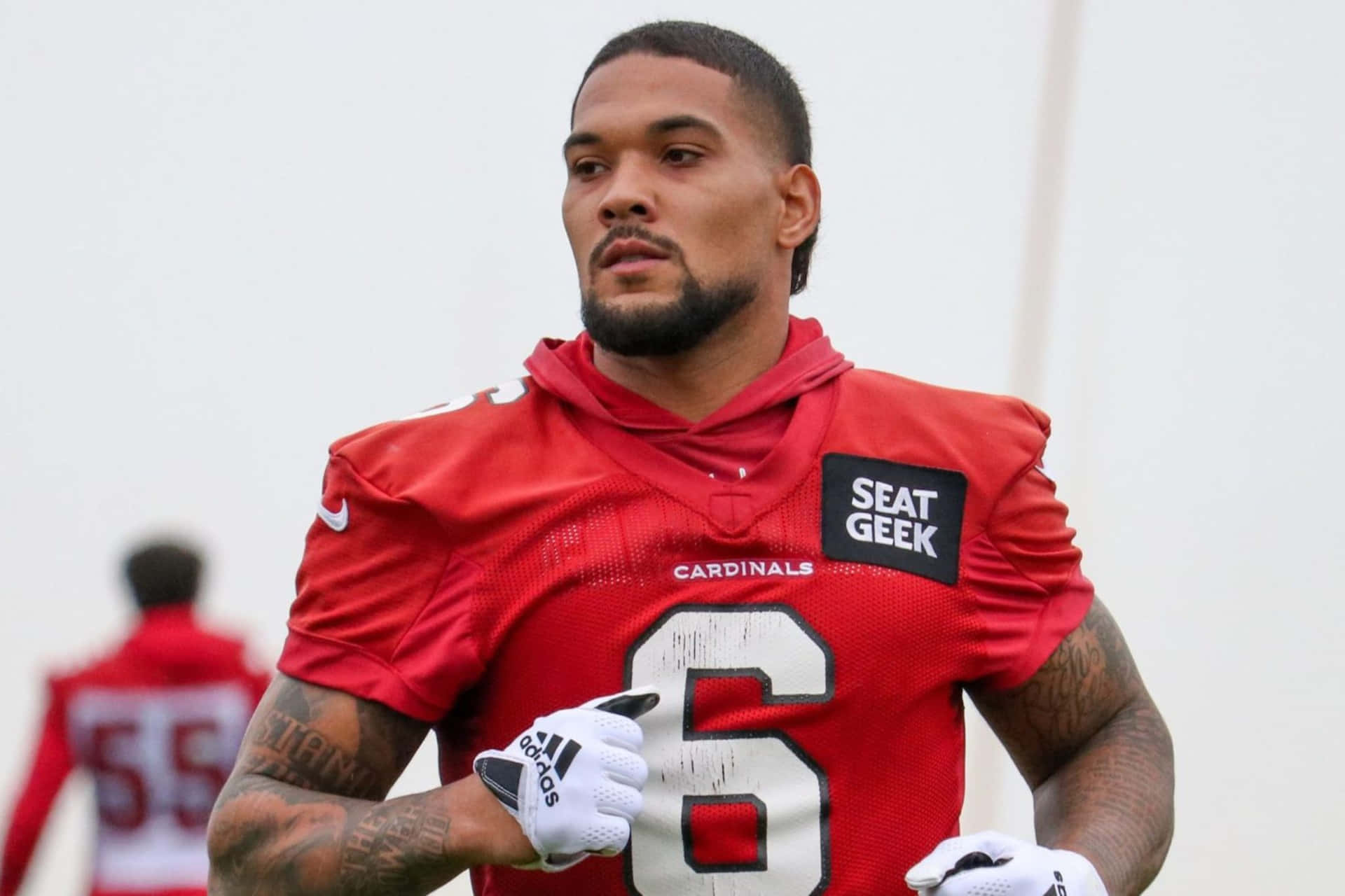  壁紙 — 一名專注的美式足球員身穿紅色 Cardinals 球衣（6號），戴著白色手套站在球場上。