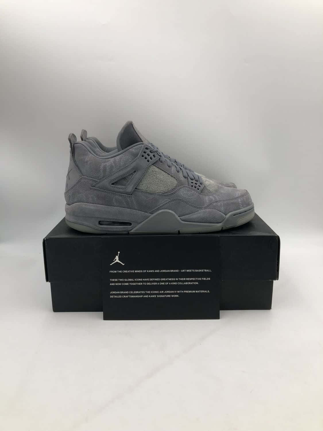 灰色麂皮Air Jordan IV運動鞋放在黑色鞋盒上，背景白色。 — Air Jordan 壁紙