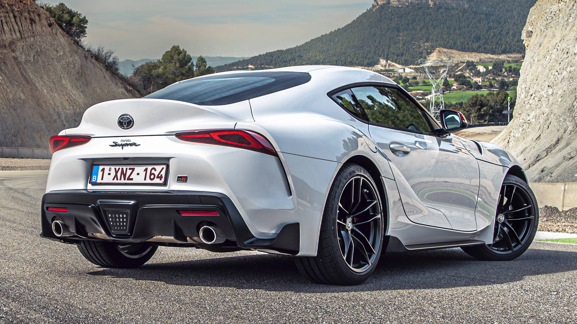 銀色豐田Supra跑車停在靠近山脈的碎石路上。 — Toyota Supra 壁紙