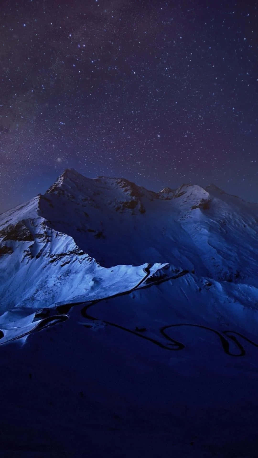 白雪覆蓋的山口，蜿蜒的道路，星空下 — 1080P 壁紙