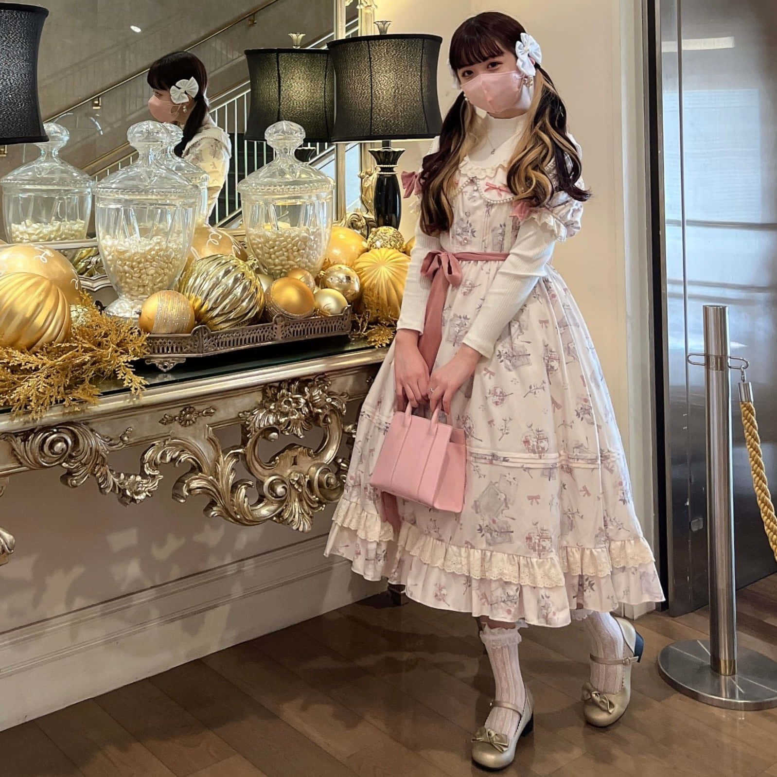 年輕女子穿著花卉裙，手持粉色包包，站在裝飾過的玄關桌旁。 — Lofi 壁紙