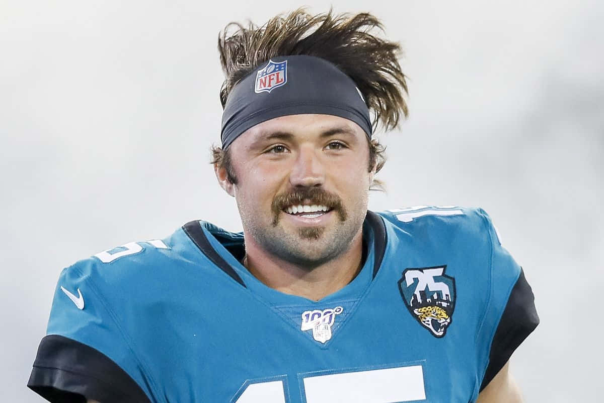  壁紙 — 一位穿著青綠色球衣、戴著頭帶、頭髮凌亂的NFL美式足球員微笑著直視鏡頭。