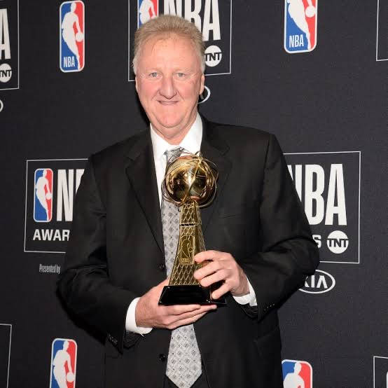 頒獎典禮上，穿西裝的男士手持NBA獎盃。 — NBA 壁紙