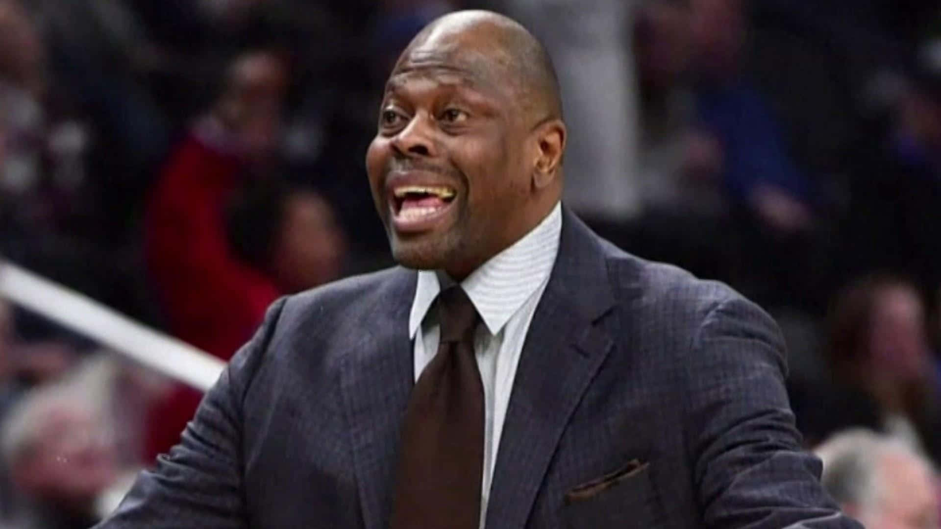 籃球教練穿著西裝打領帶在比賽中大笑。 — NBA 壁紙