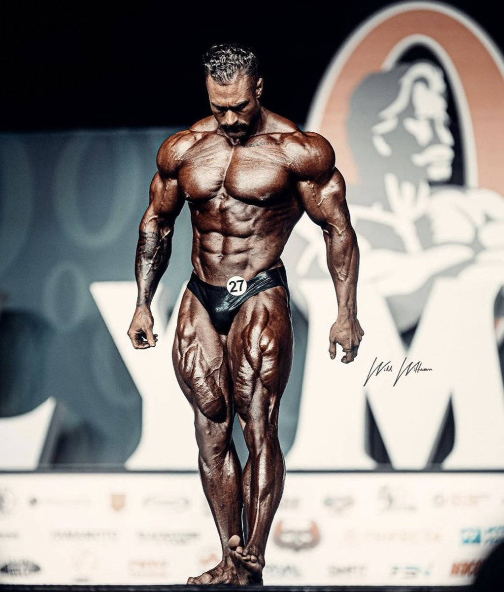 健美運動員27號在比賽期間在舞台上擺姿勢。 — Chris Bumstead 壁紙