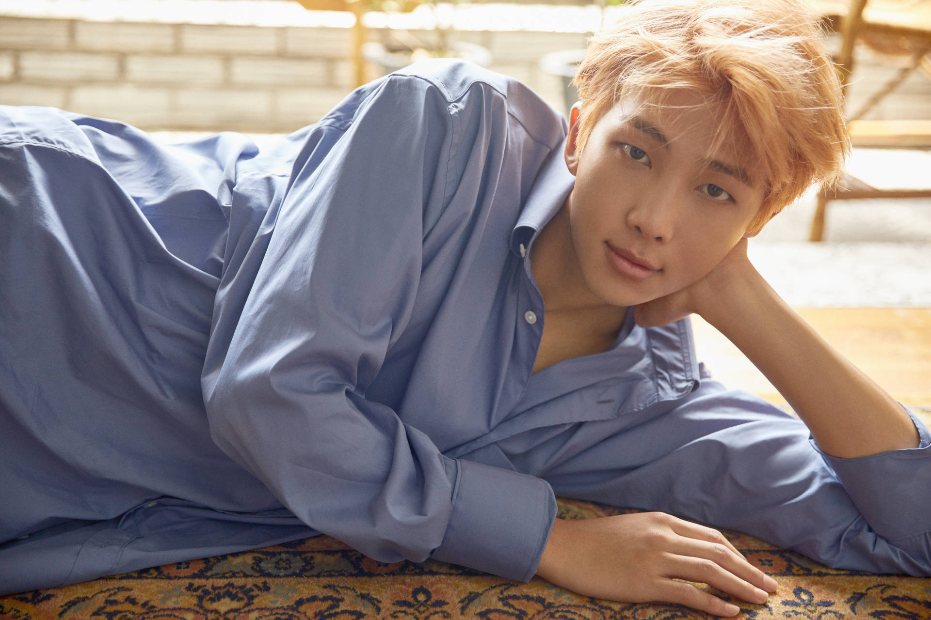 穿著藍色襯衫躺在圖案地毯上的年輕男子 — Bts 壁紙