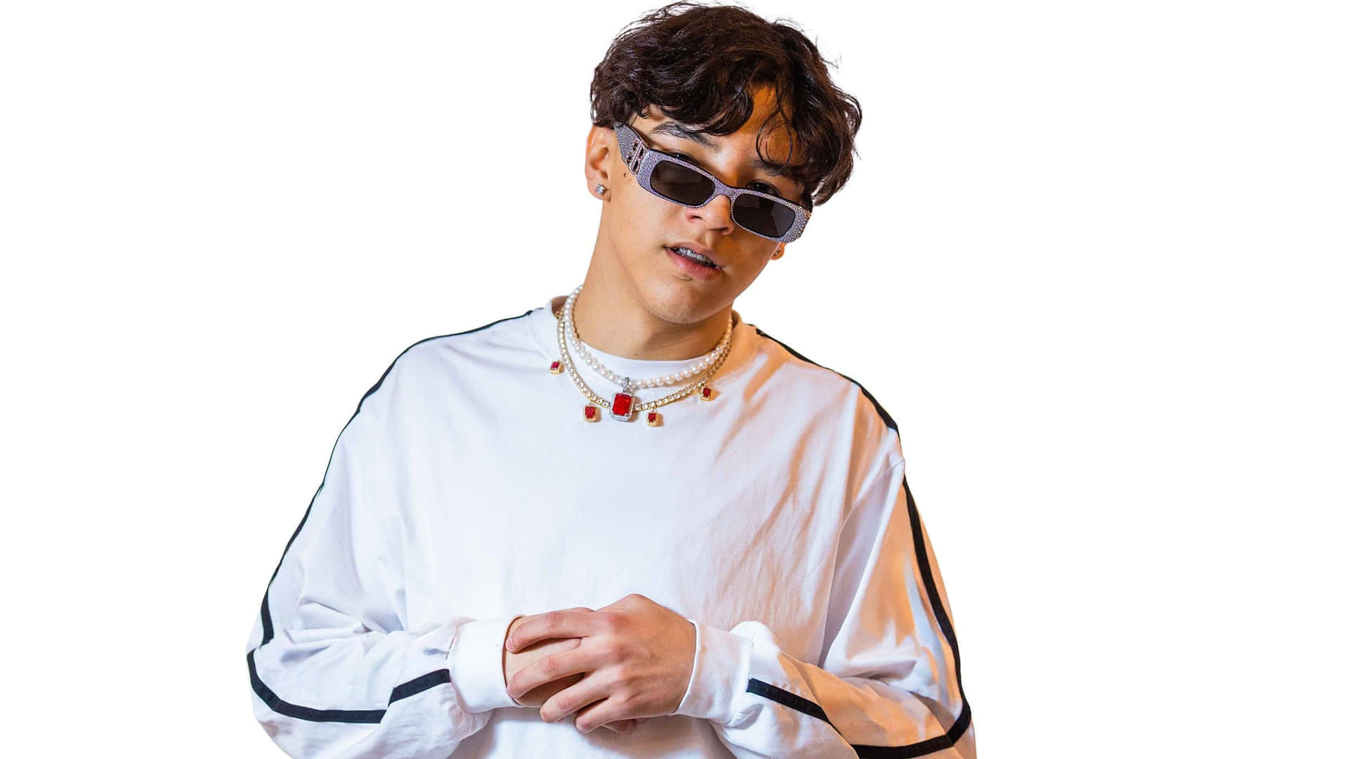  壁紙 — 一位捲髮年輕男士戴著時尚太陽眼鏡、多層項鍊和白色長袖襯衫，背景為純白色。