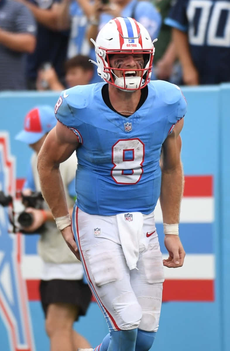 壁紙 — 一位決心堅定的NFL四分衛，身穿淺藍色8號球衣，在日間比賽中於足球場上前進。
