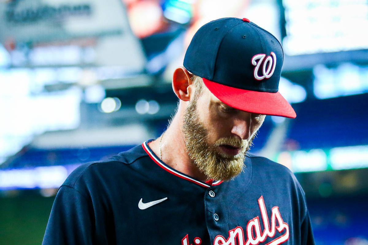 穿著國民隊球衣的棒球運動員在球場上低頭看著 — MLB 壁紙