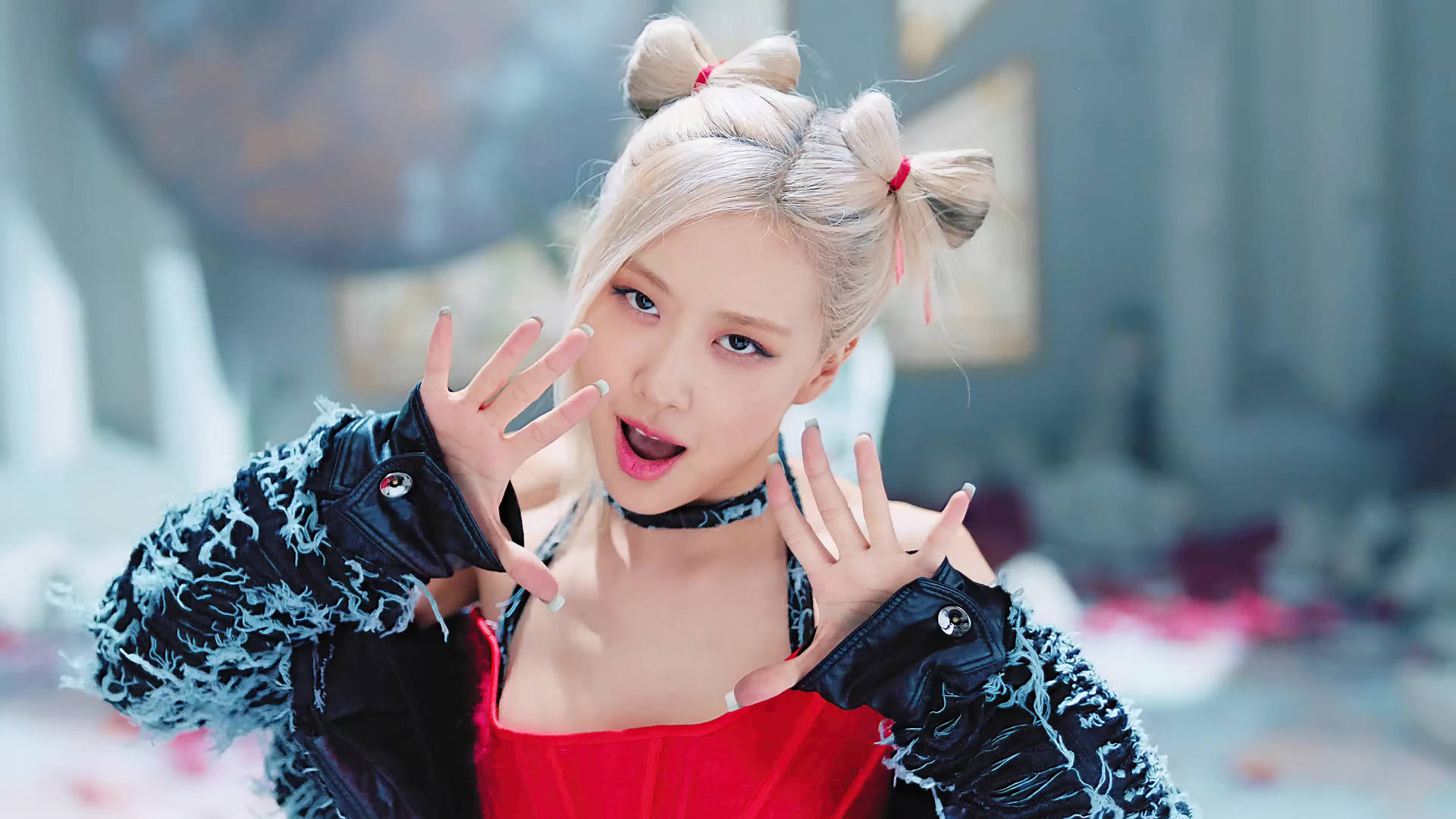 金色雙丸子頭、紅色服裝的年輕女性在室內俏皮地擺姿勢。 — Blackpink 壁紙
