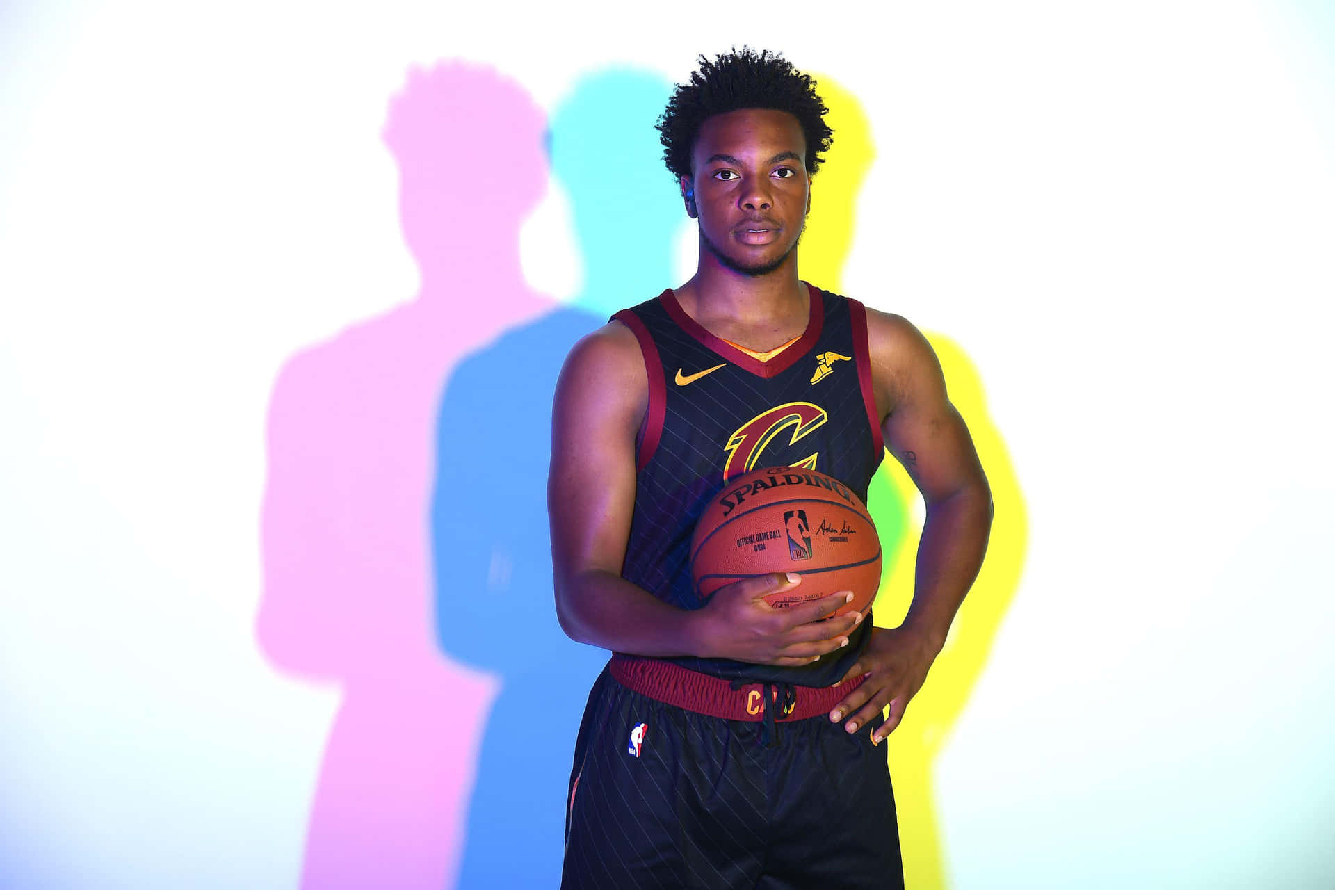 身穿騎士隊球衣的籃球運動員手持籃球，背後有彩色陰影。 — NBA 壁紙