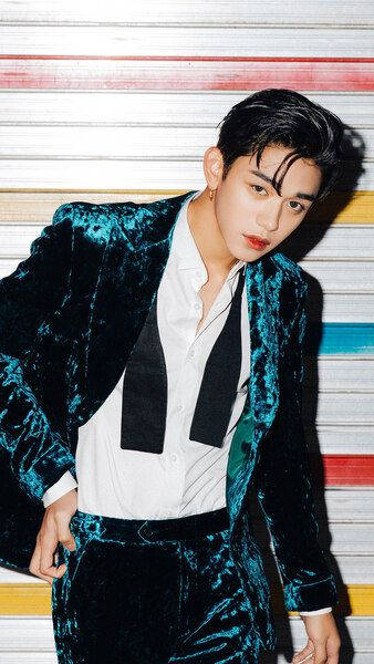 身穿青綠色天鵝絨西裝的年輕男子在條紋牆前擺姿勢 — K Pop 壁紙