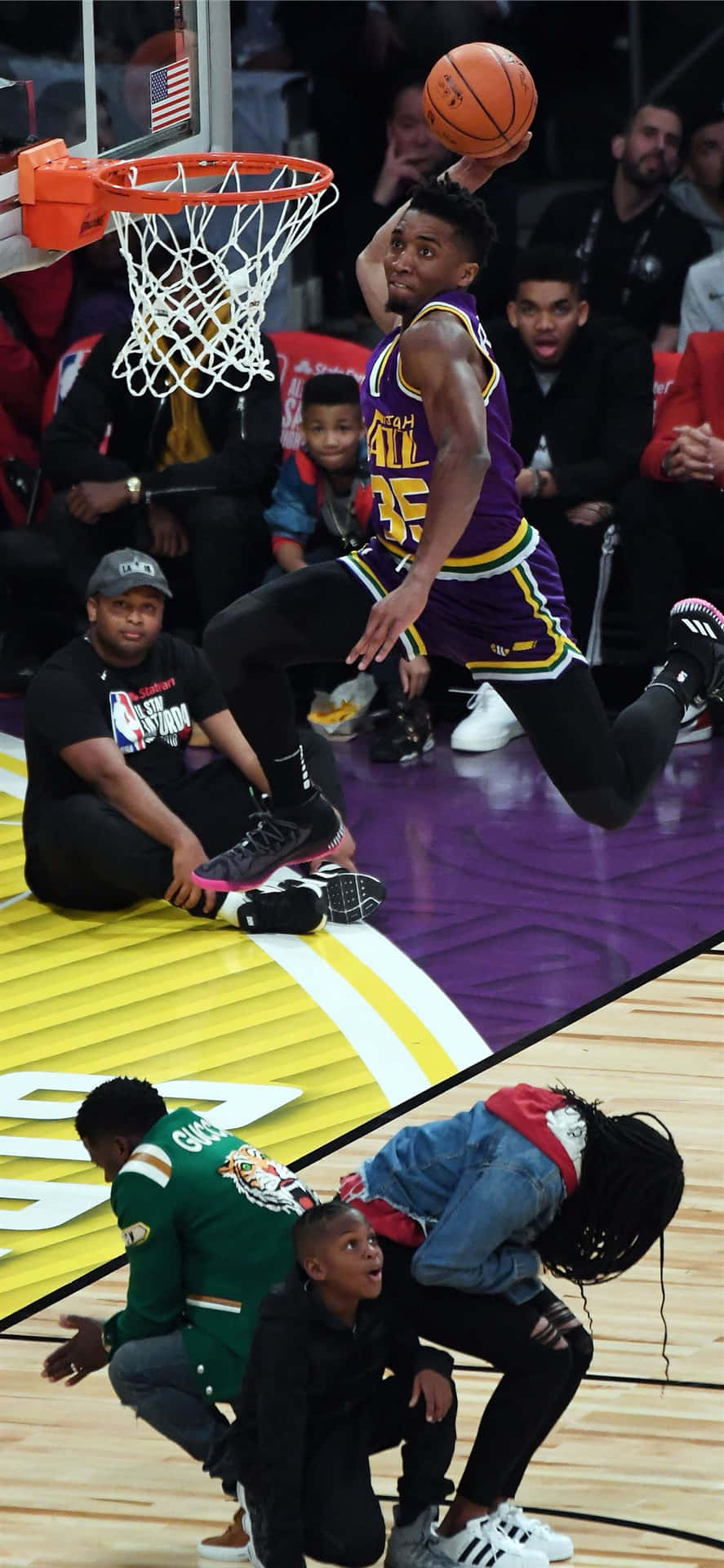 籃球運動員在比賽中灌籃，球迷和孩子們在觀看。 — NBA 壁紙