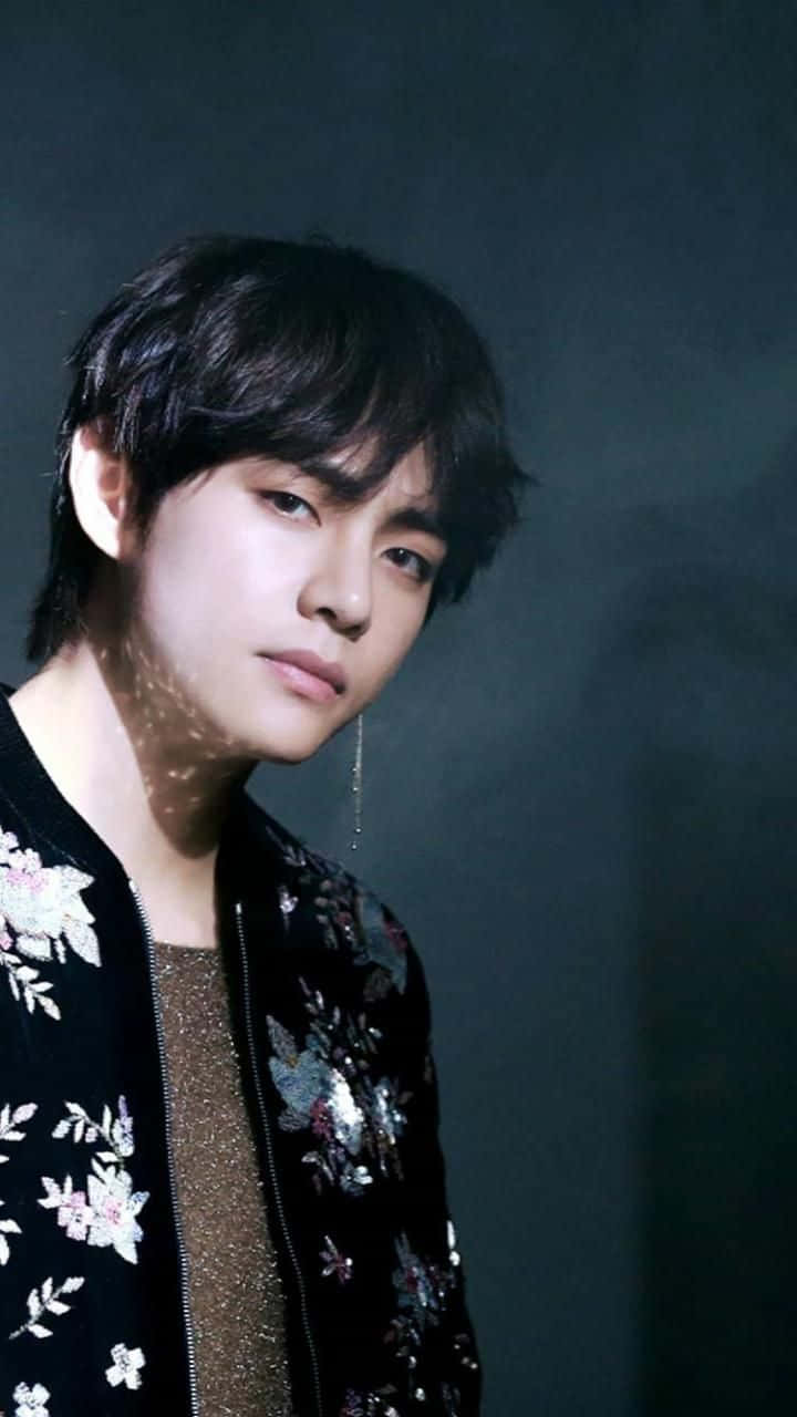 年輕男子穿著花卉圖案外套，柔和光線映襯灰色背景 — Bts 壁紙