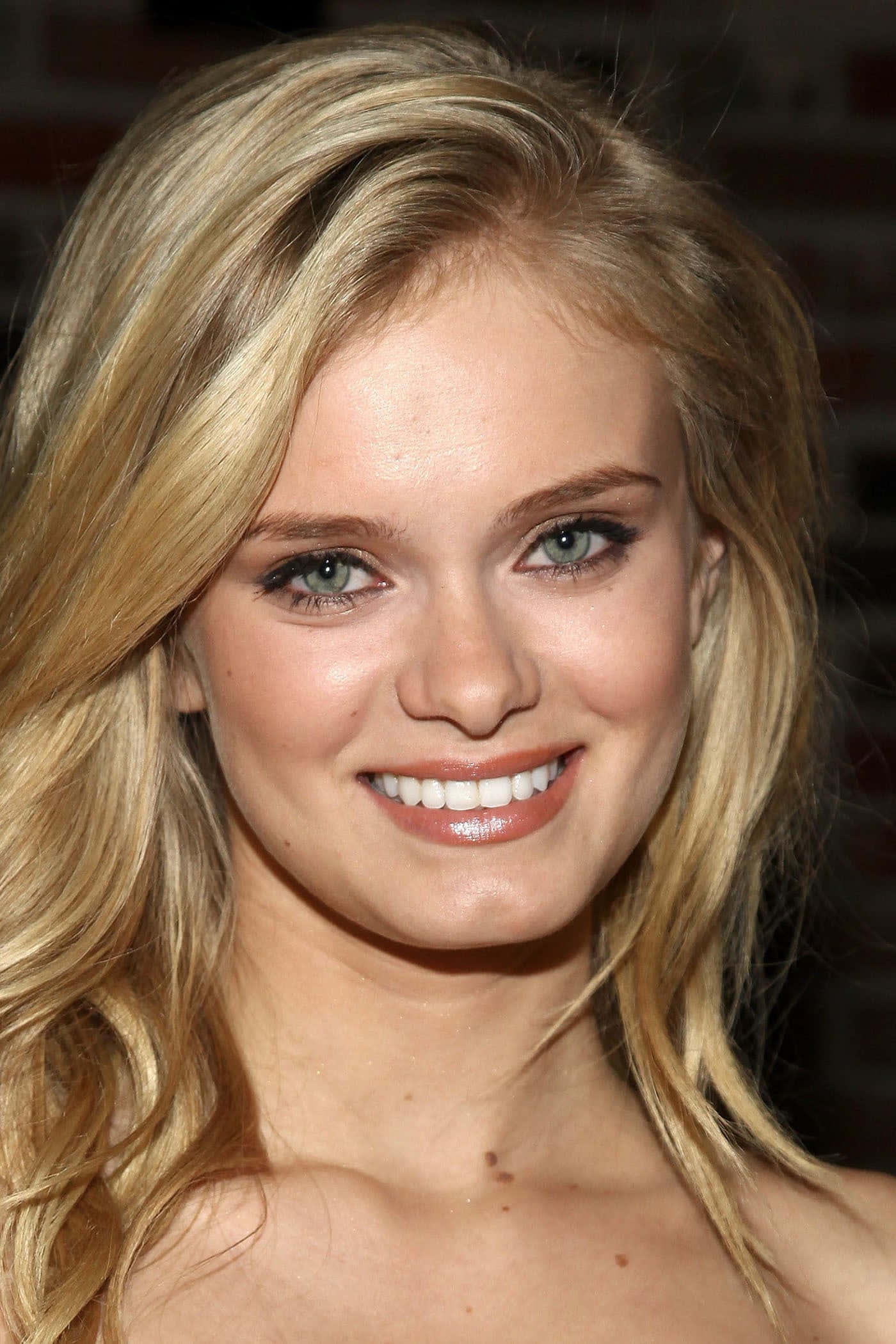 Sara Paxton 桌布 壁紙 — 一位微笑金髮女子的近距離肖像，擁有明亮的藍眼睛和柔軟的波浪頭髮。