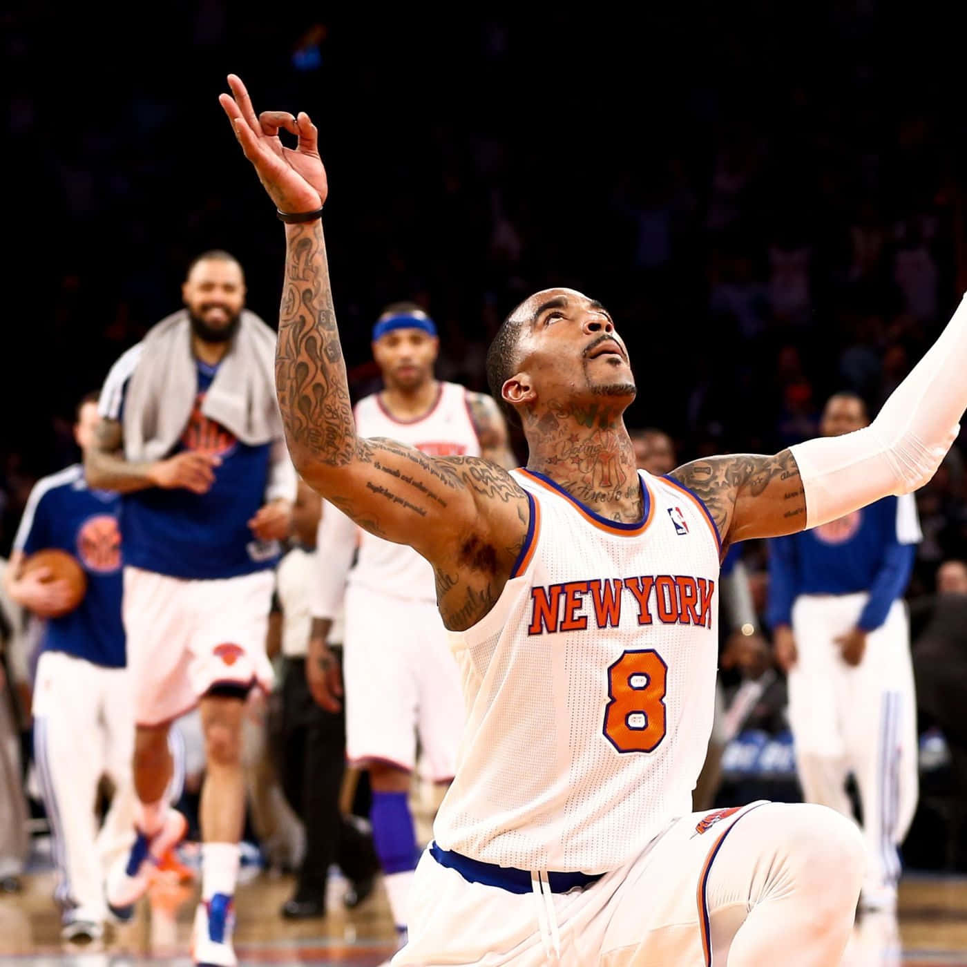 籃球運動員在球場上舉臂慶祝勝利。 — NBA 壁紙
