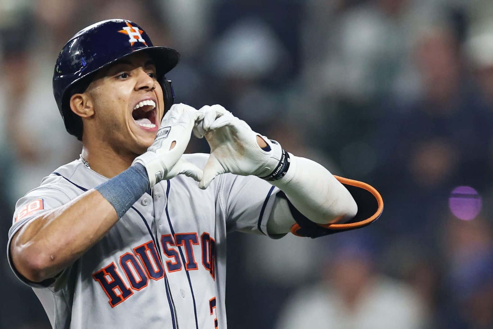  壁紙 — 一位休士頓太空人棒球選手在夜間比賽中，於球場燈光下以心形手勢慶祝。