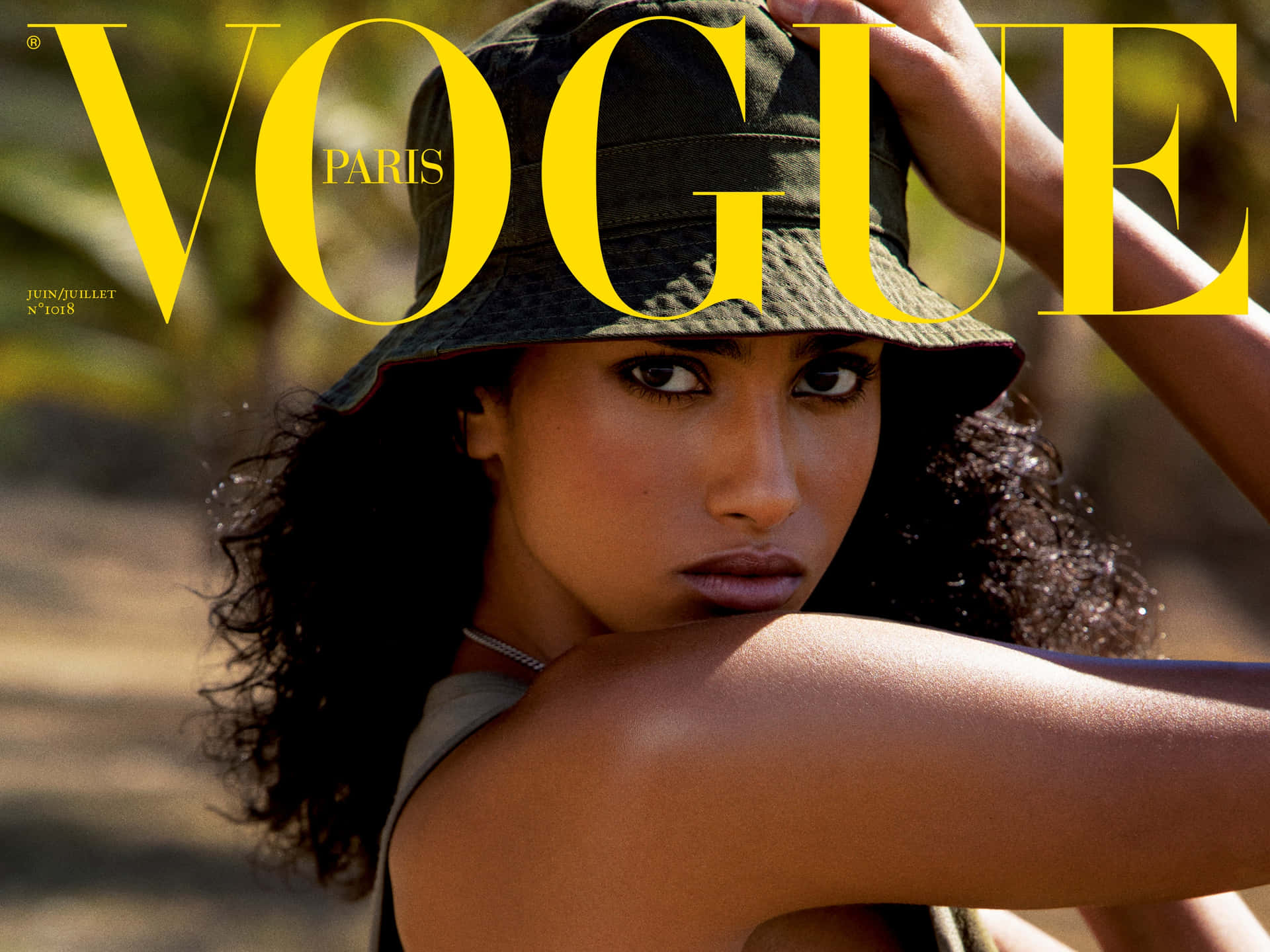  壁紙 — 一位擁有捲髮和漁夫帽的女性在醒目的黃色Vogue Paris文字下強烈地凝視鏡頭。
