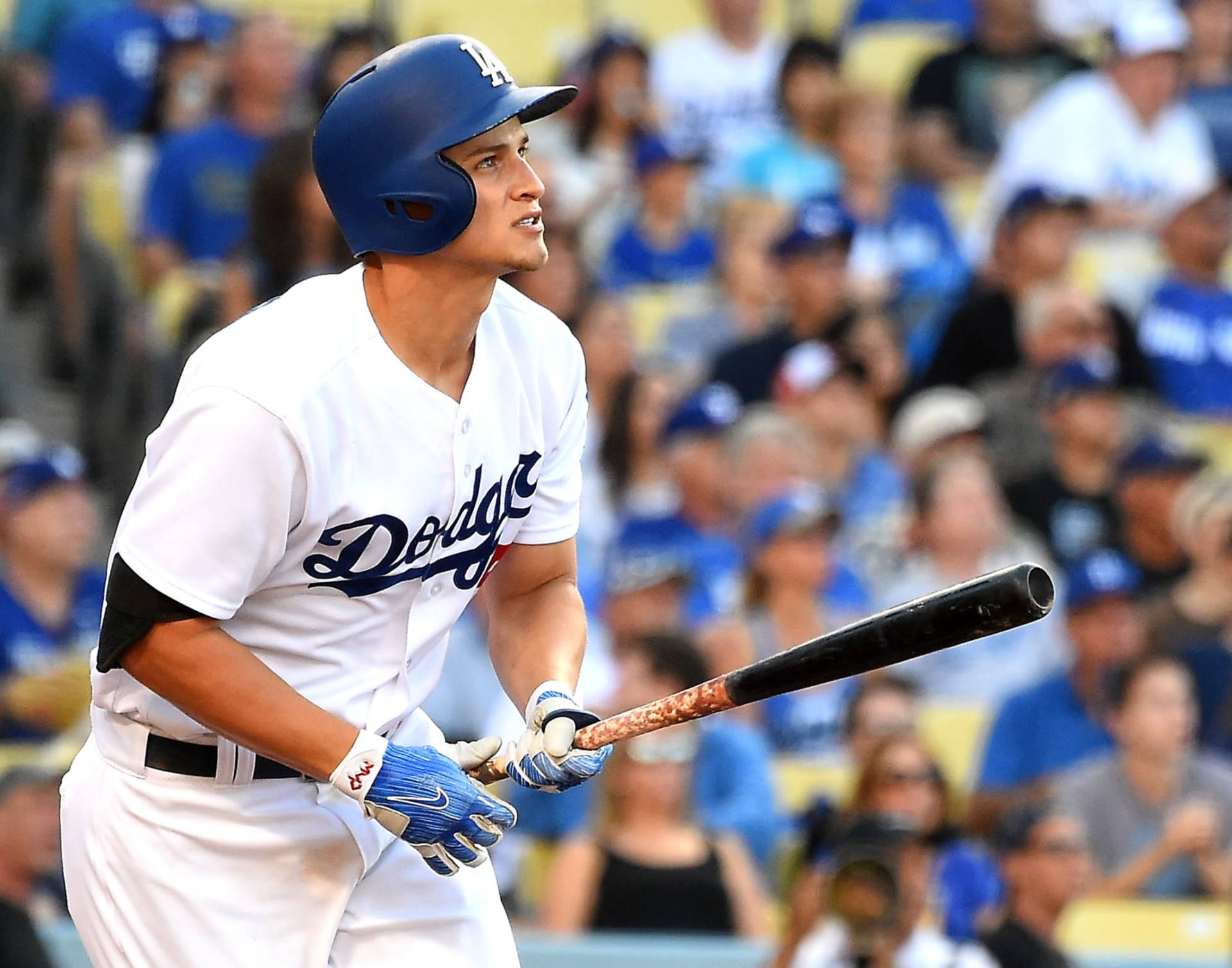 身穿道奇隊制服的棒球運動員在比賽中持球棒，背後有群眾。 — MLB 壁紙