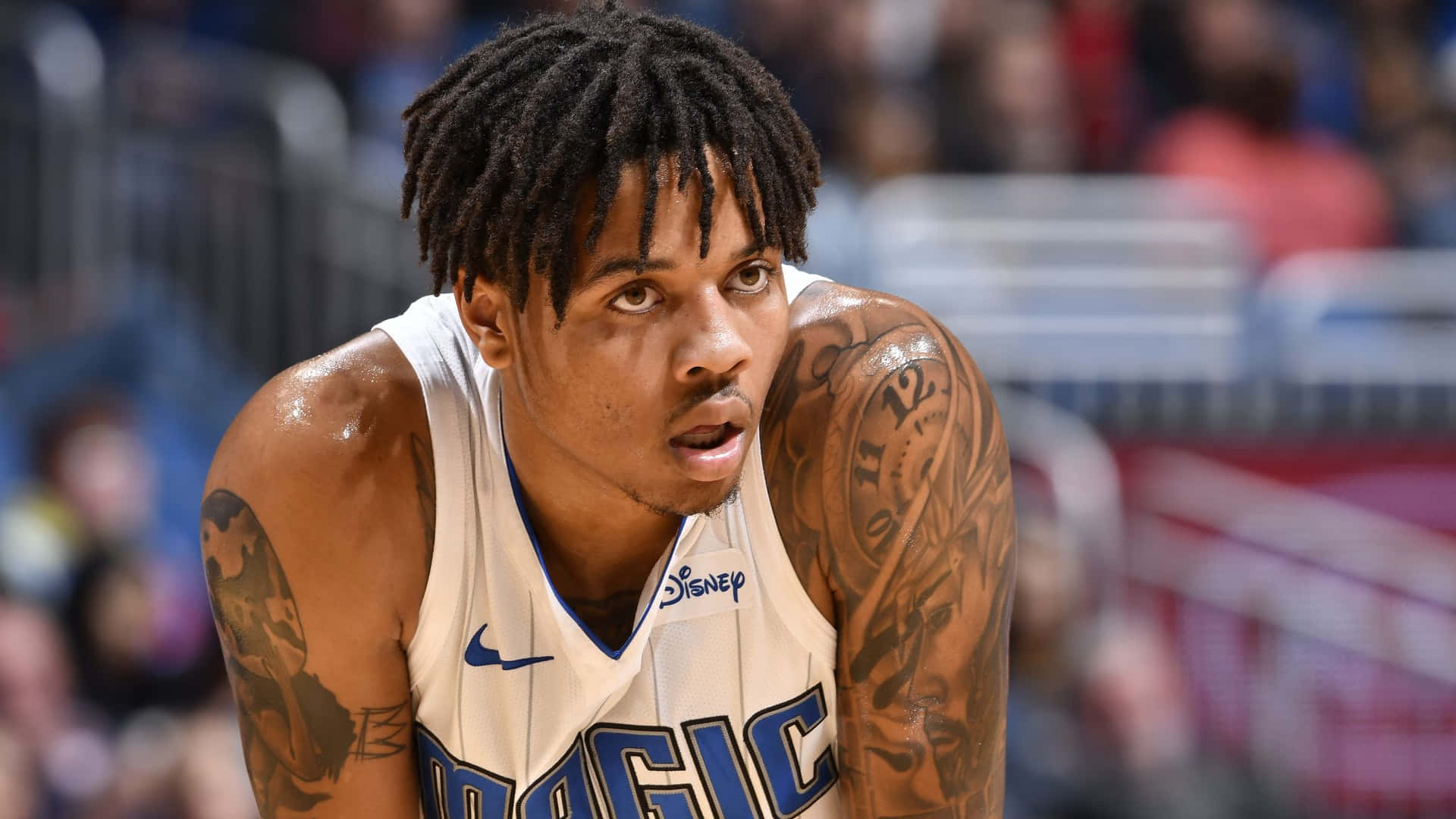 比賽中穿著奧蘭多魔術隊球衣、有刺青和辮子頭的籃球運動員。 — NBA 壁紙